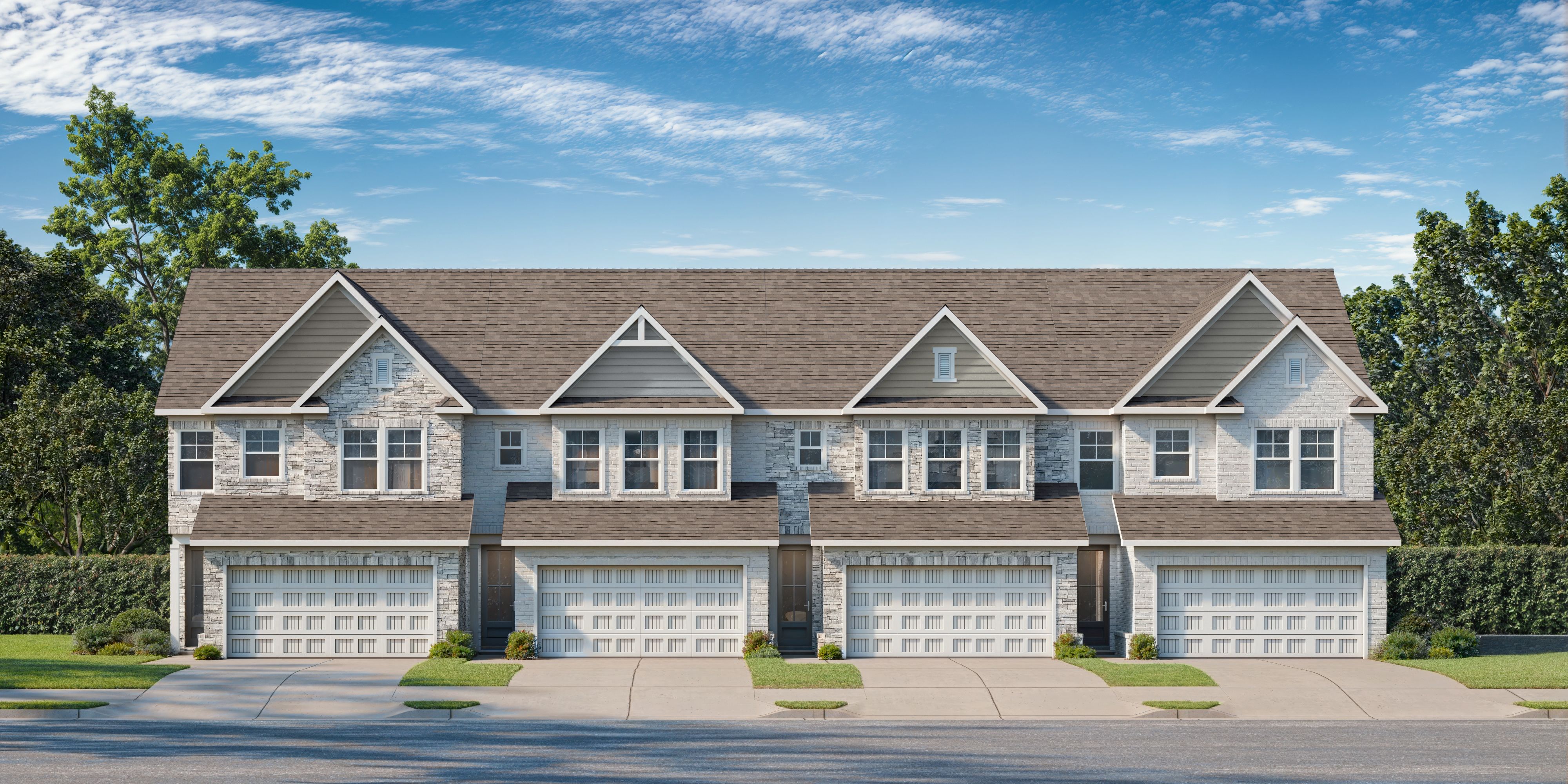 Row of modern townhomes at Lake Shore in Winder, Georgia with gabled roofs, attached garages and lush green landscaping