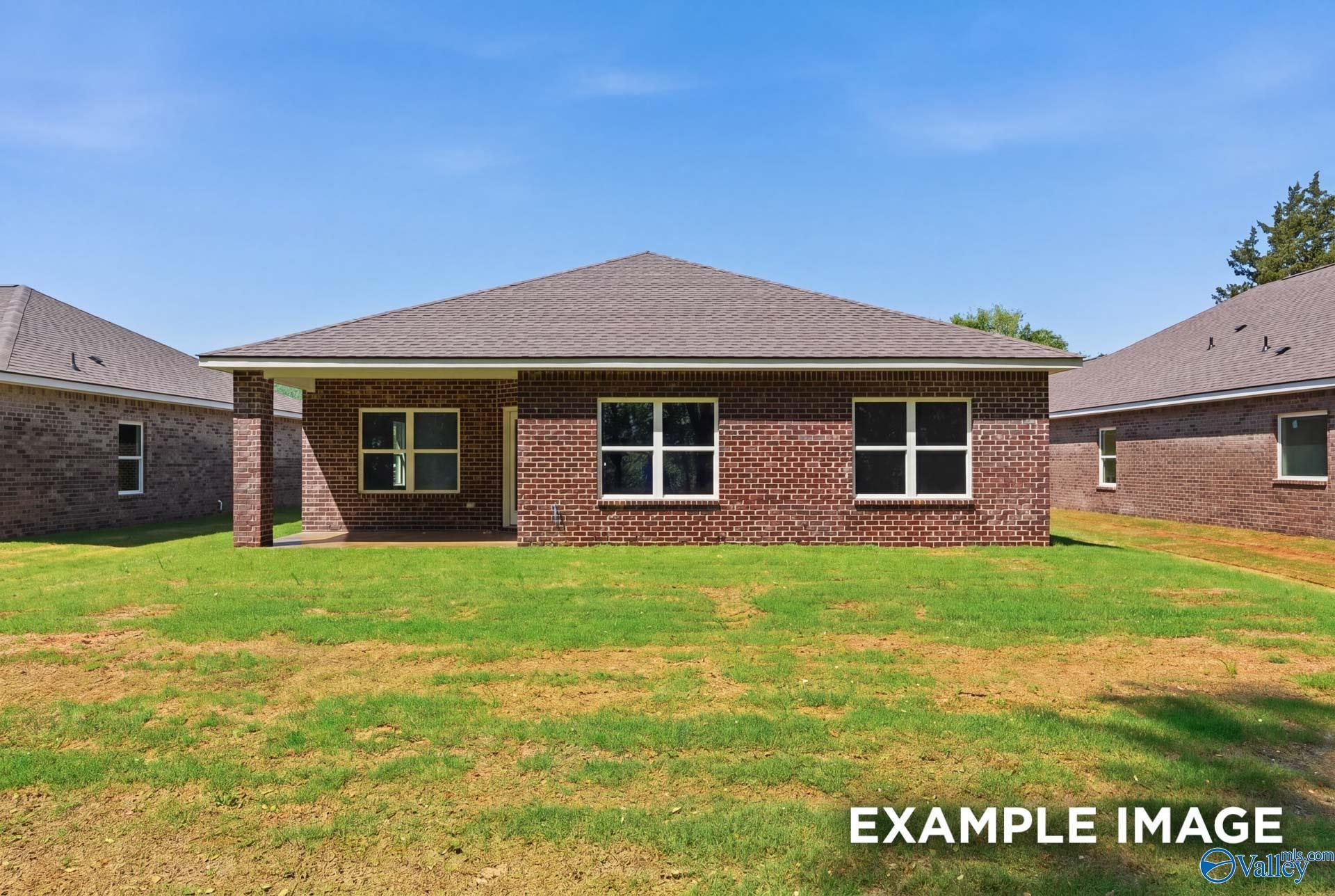 Rear view of a brick Franklin C floor plan home by Davidson Homes with a covered patio in The Highlands, Arab, Alabama.