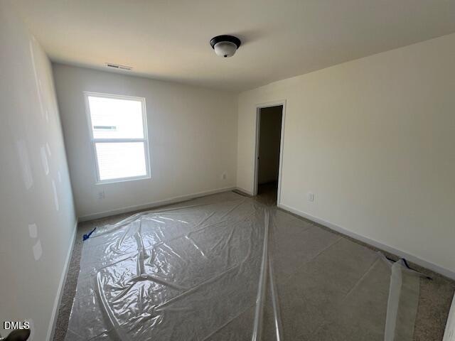 Unfinished carpeted bedroom in The Hickory II B floor plan by Davidson Homes at Retreat at North Main in Lillington, NC.