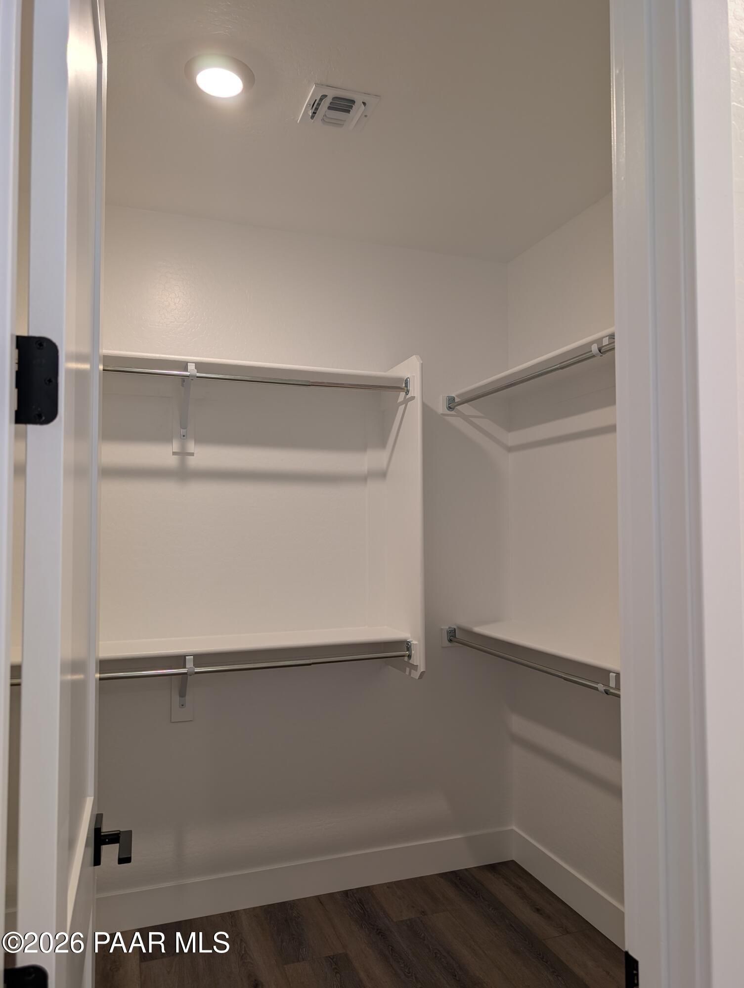 Spacious walk-in closet with metal shelving rods and hardwood floors in Davidson Homes The Sheridan II G, Prescott, Arizona