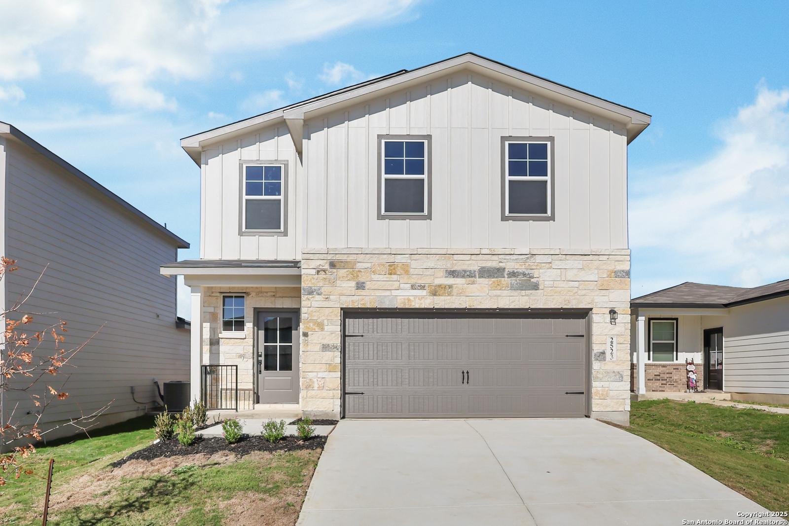 Modern two-story home with stone accents, two-car garage, and covered porch in Applewhite Meadows, San Antonio, Texas