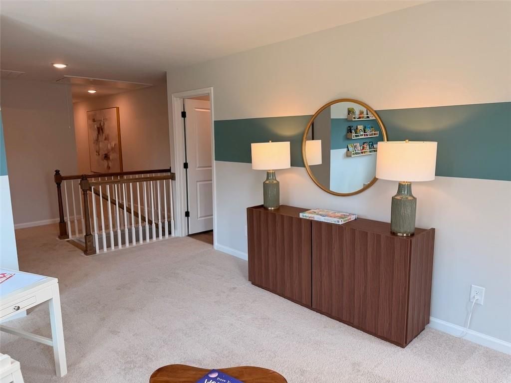 Upstairs loft with accent wall, round mirror, and wood console in Davidson Homes Pinecrest J, Greene Farm, Cartersville GA