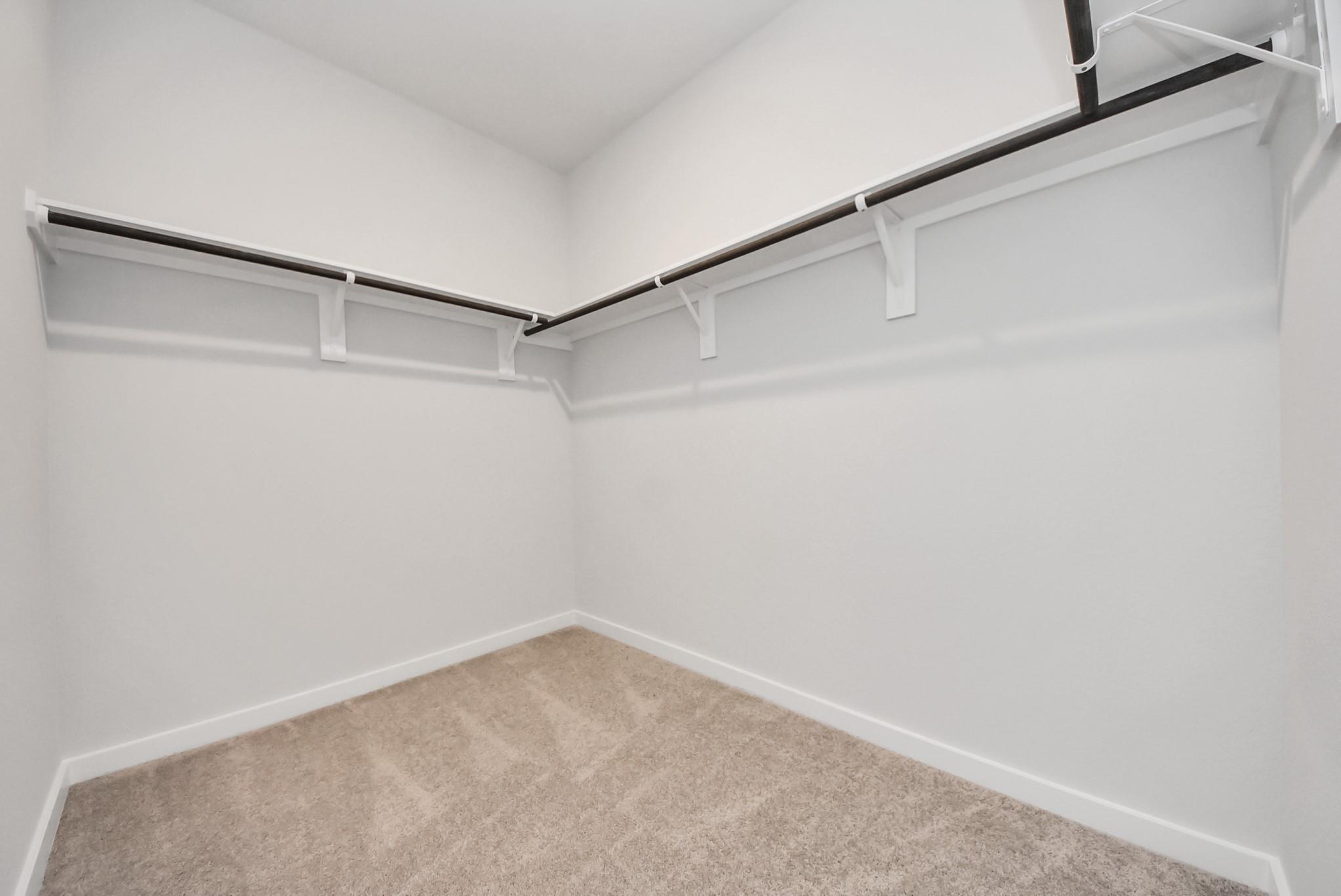 Walk-in closet with built-in shelving in The Blanco E floor plan at The Villages at WestPointe, Dayton, Texas.