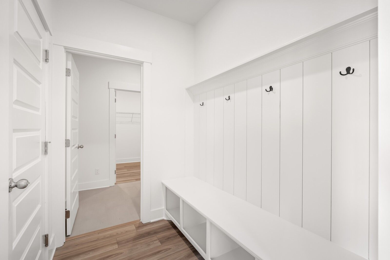 Spacious white mudroom with built-in bench, coat hooks, and cubbies in Davidson Homes The Ash C, Mt. Juliet, TN