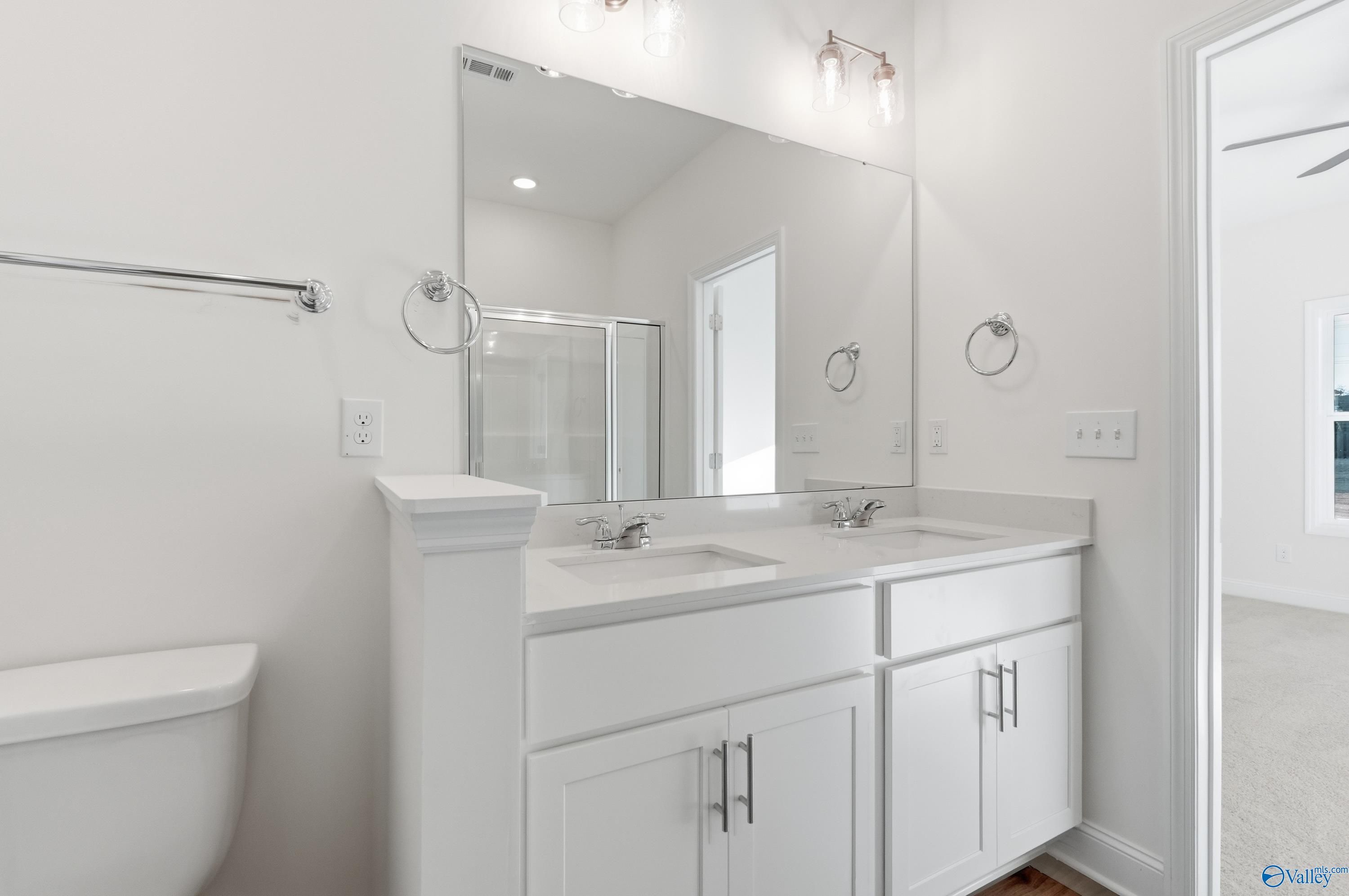 Modern master bathroom with double vanity, frameless shower, and large mirror in Davidson Homes The Asheville C, Meridianville, AL