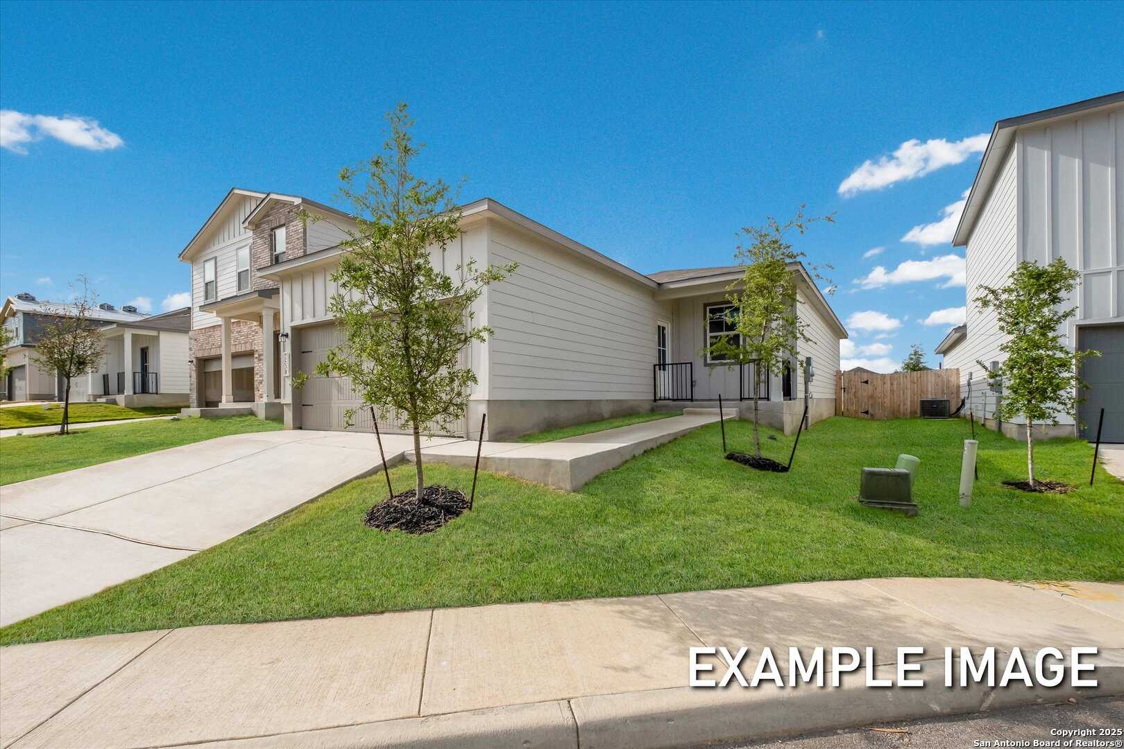 Modern 1-story beige home with 2-car garage, young trees, and lush green lawn in Agave, San Antonio, Texas