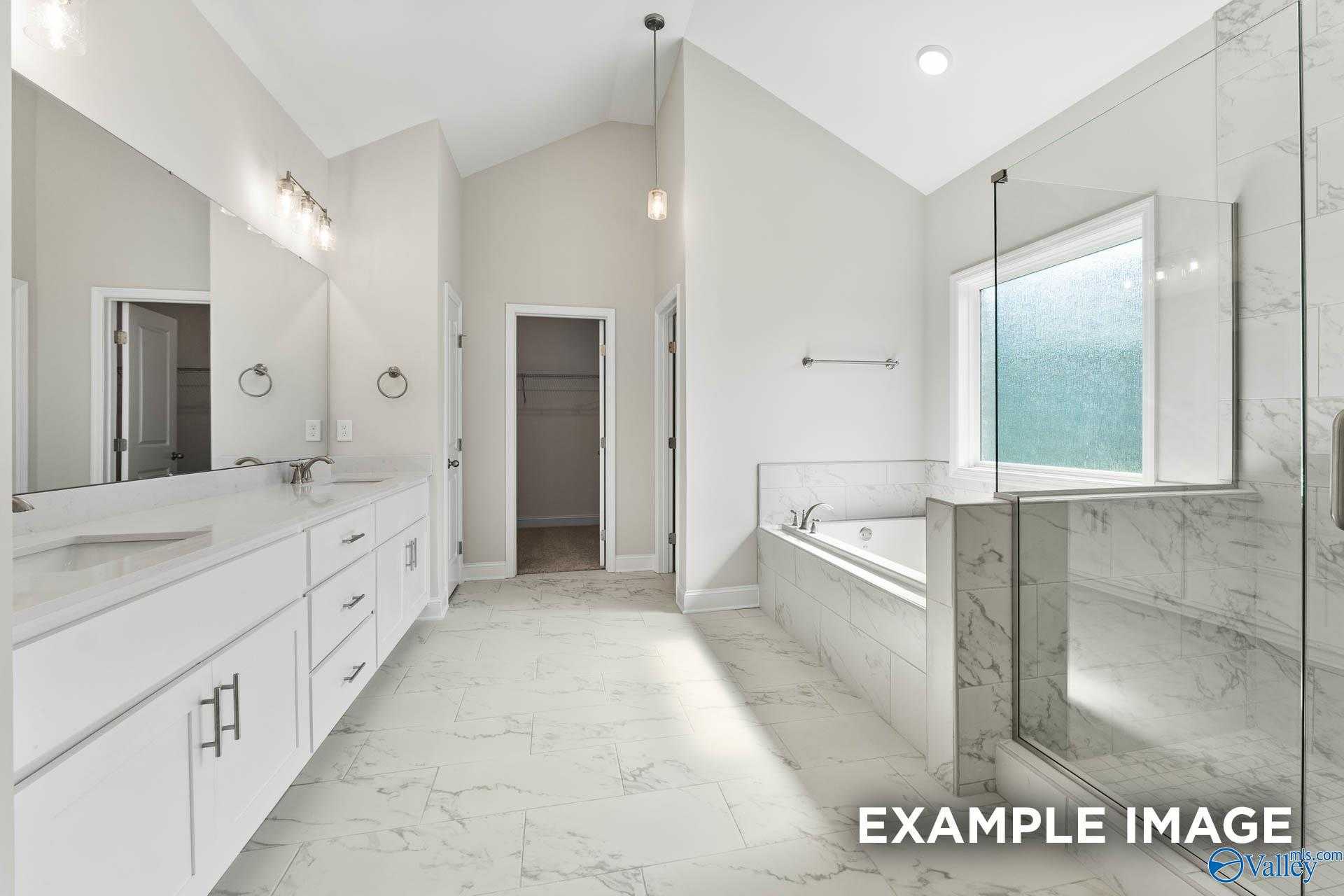Elegant master bath with white double vanity, marble counters, freestanding tub, and glass shower in Davidson Homes The Finleigh, Meridianville, AL