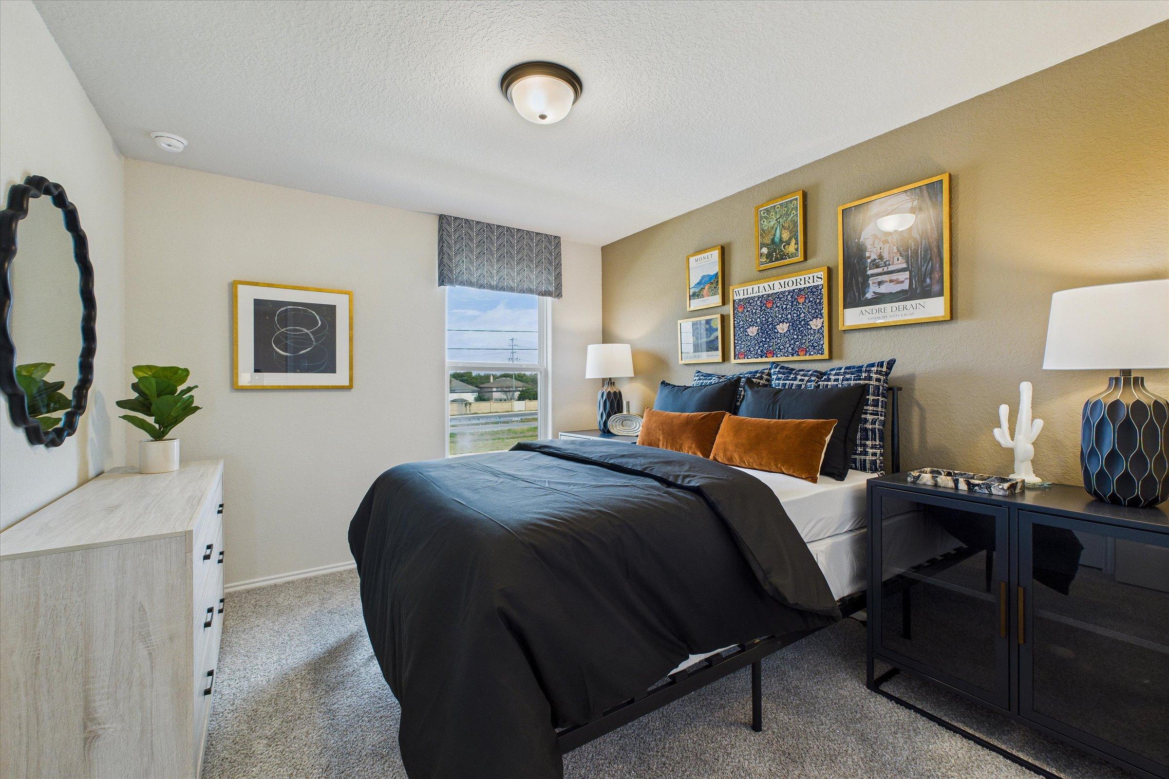 Spacious modern bedroom at Meadows at Oak Creek in San Antonio TX with king bed, neutral walls, artwork and plants
