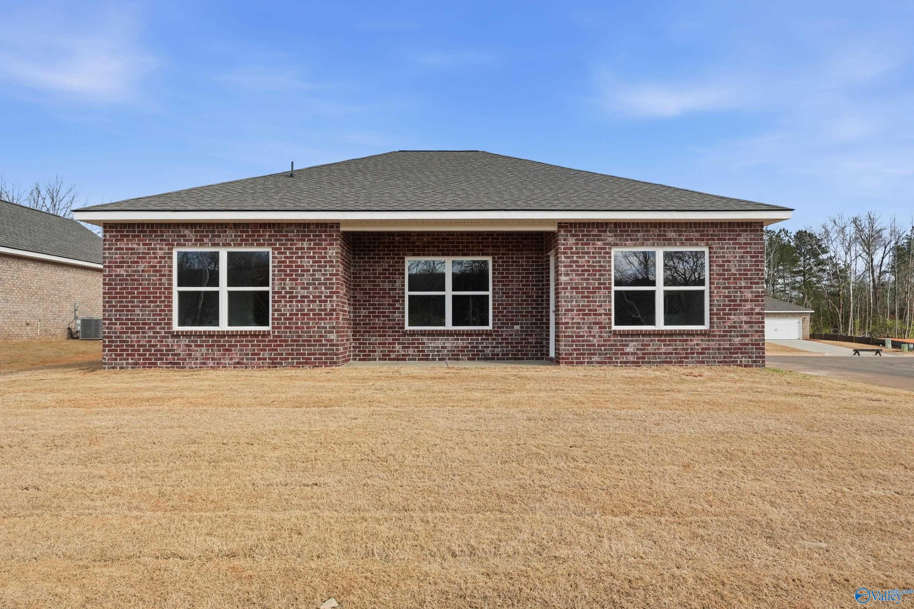 Single-story brick home with gabled roof, three front windows, and covered entry porch in Spragins Cove, Huntsville, Alabama