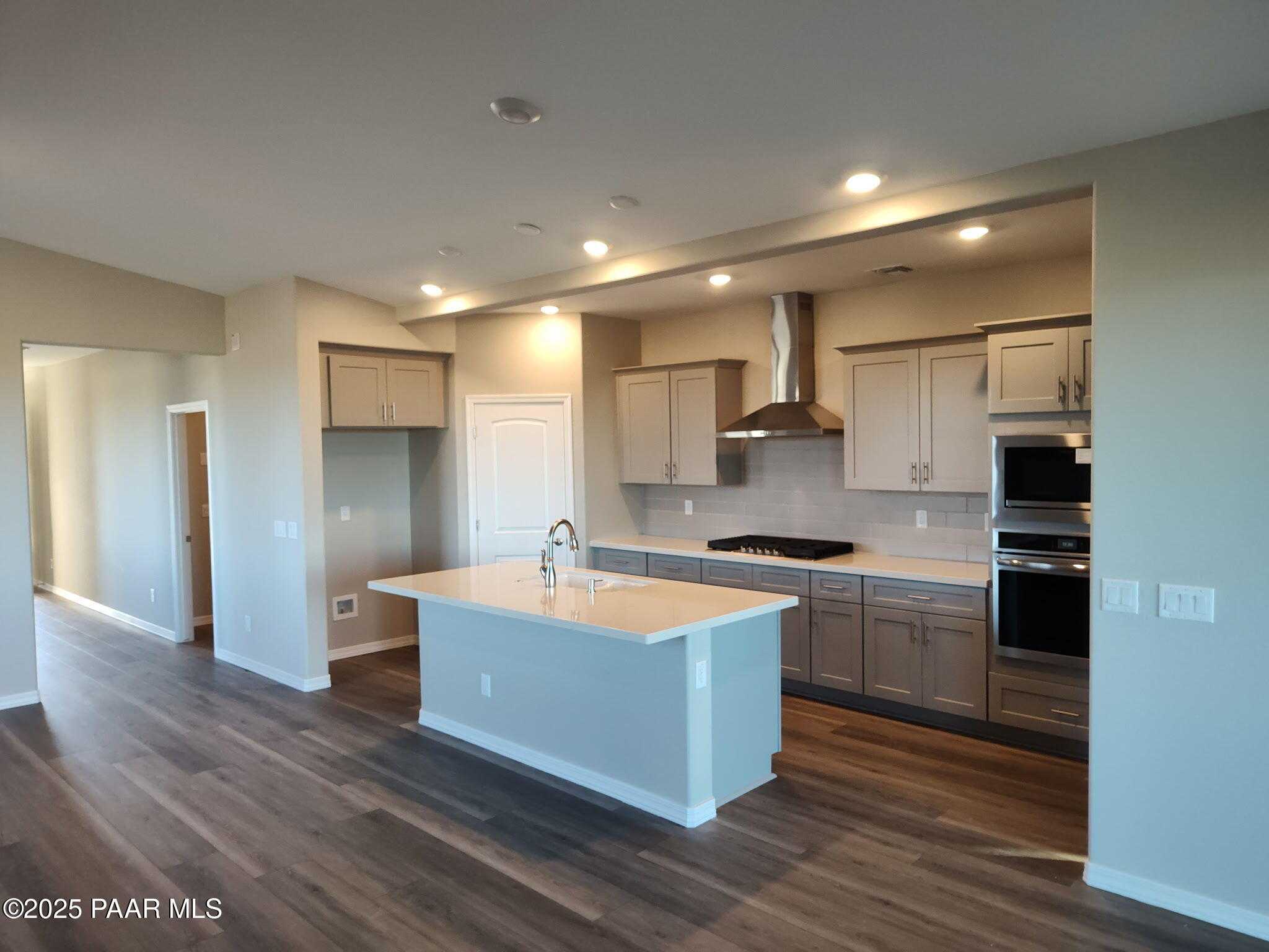 Modern open-concept kitchen with central island sink, stainless steel appliances, and recessed lighting in Davidson Homes The Frontier A, Prescott Valley, Arizona