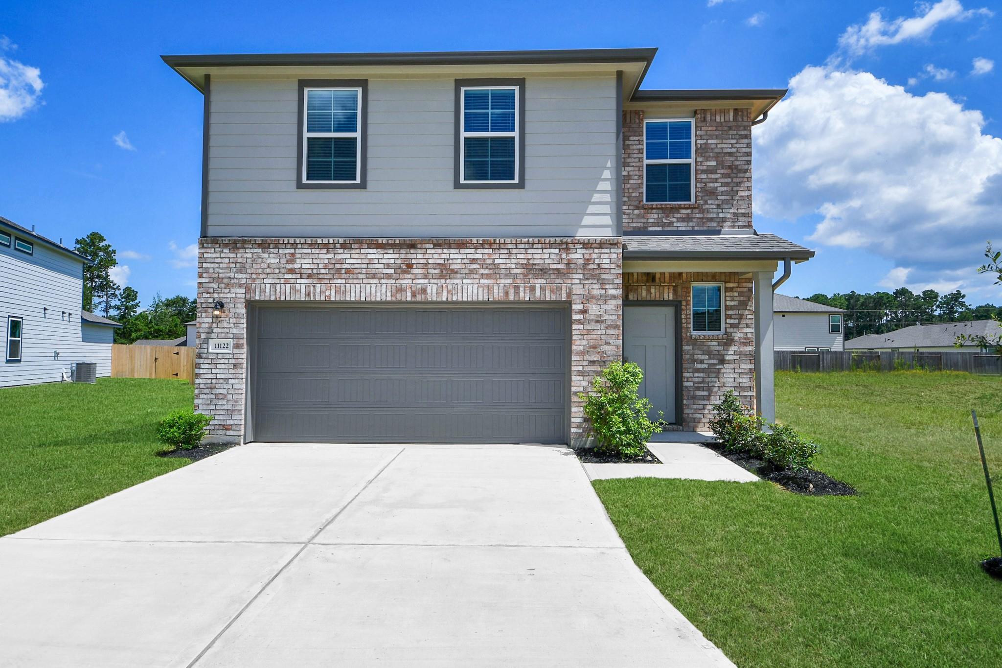 Two-story Davidson Homes Brazos F floor plan with brick facade and two-car garage in Liberty Estates, Cleveland, Texas.