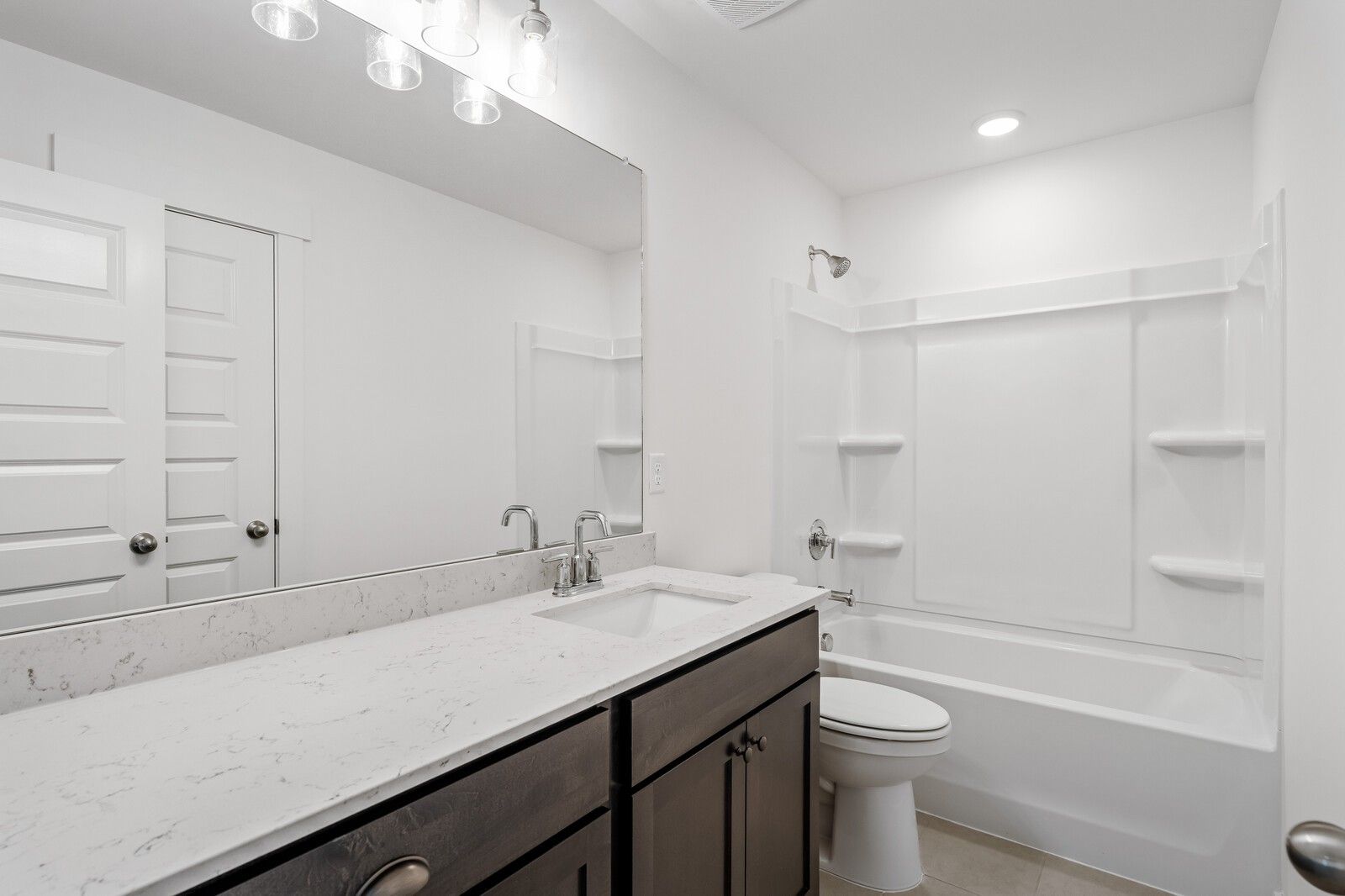 Modern bathroom with white vanity, marble-style countertop, and tub-shower combo in Woods Crossing, Gallatin, Tennessee.