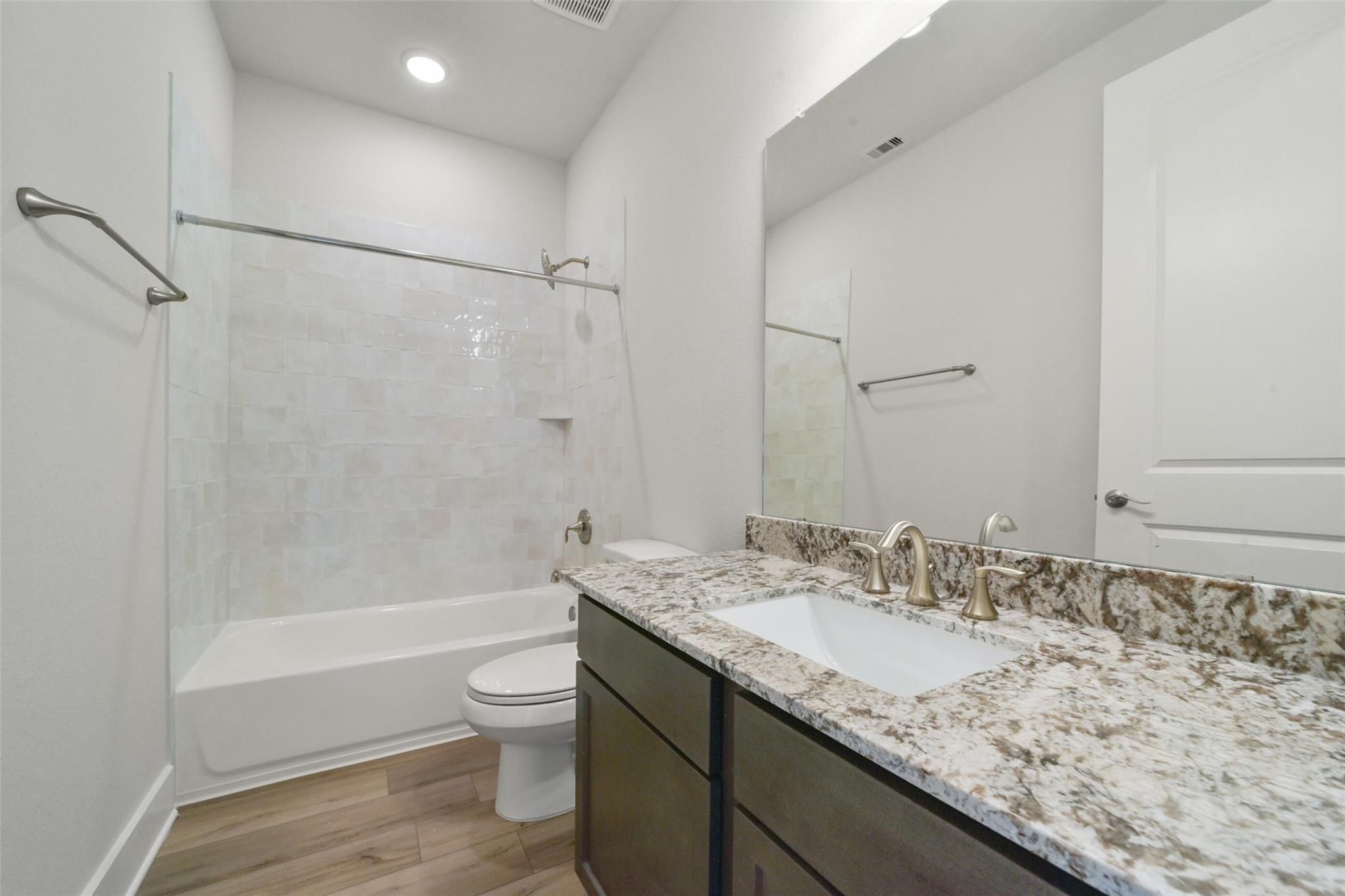 Modern bathroom with subway tile shower, soaking tub, quartz double vanity in Davidson Homes The Zion A, Lago Mar, Texas City