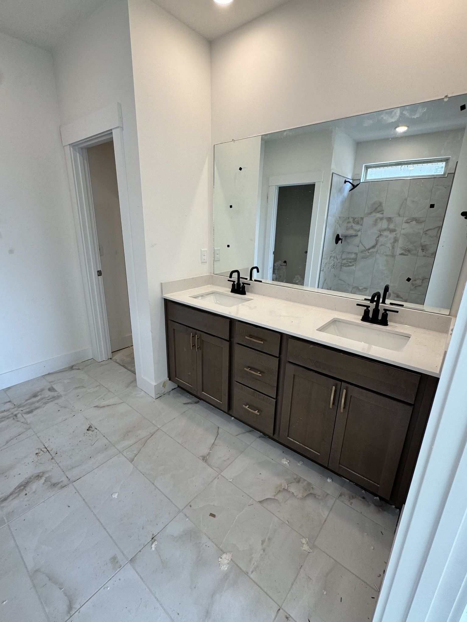 Modern master bathroom with double quartz vanity, shaker cabinets, large mirror, and marble tile shower in Davidson Homes The Prairie C, Gallatin, Tennessee