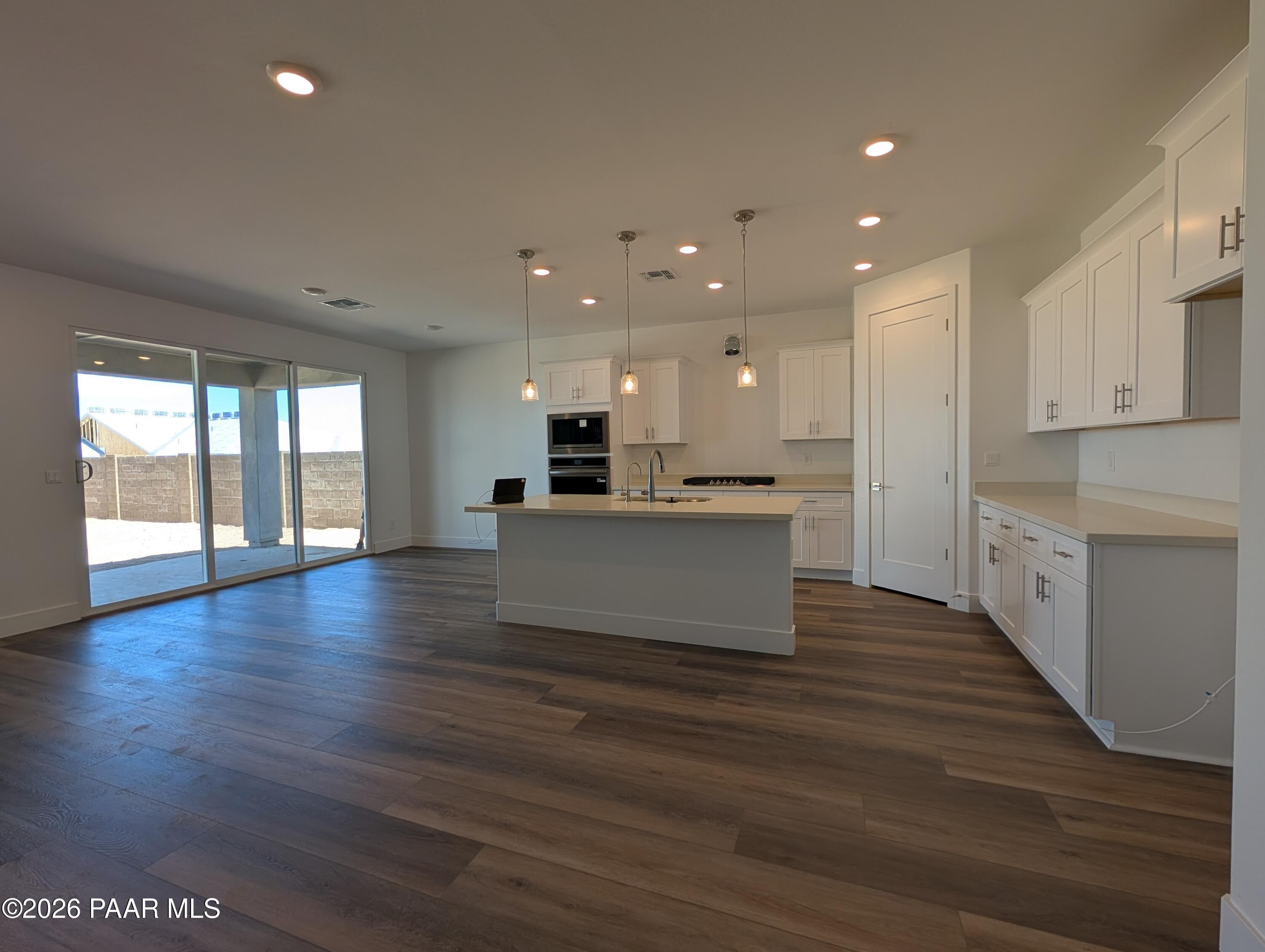 Modern open-concept kitchen with white cabinets and island in The Durango II F floor plan at South Ranch, Prescott, AZ.