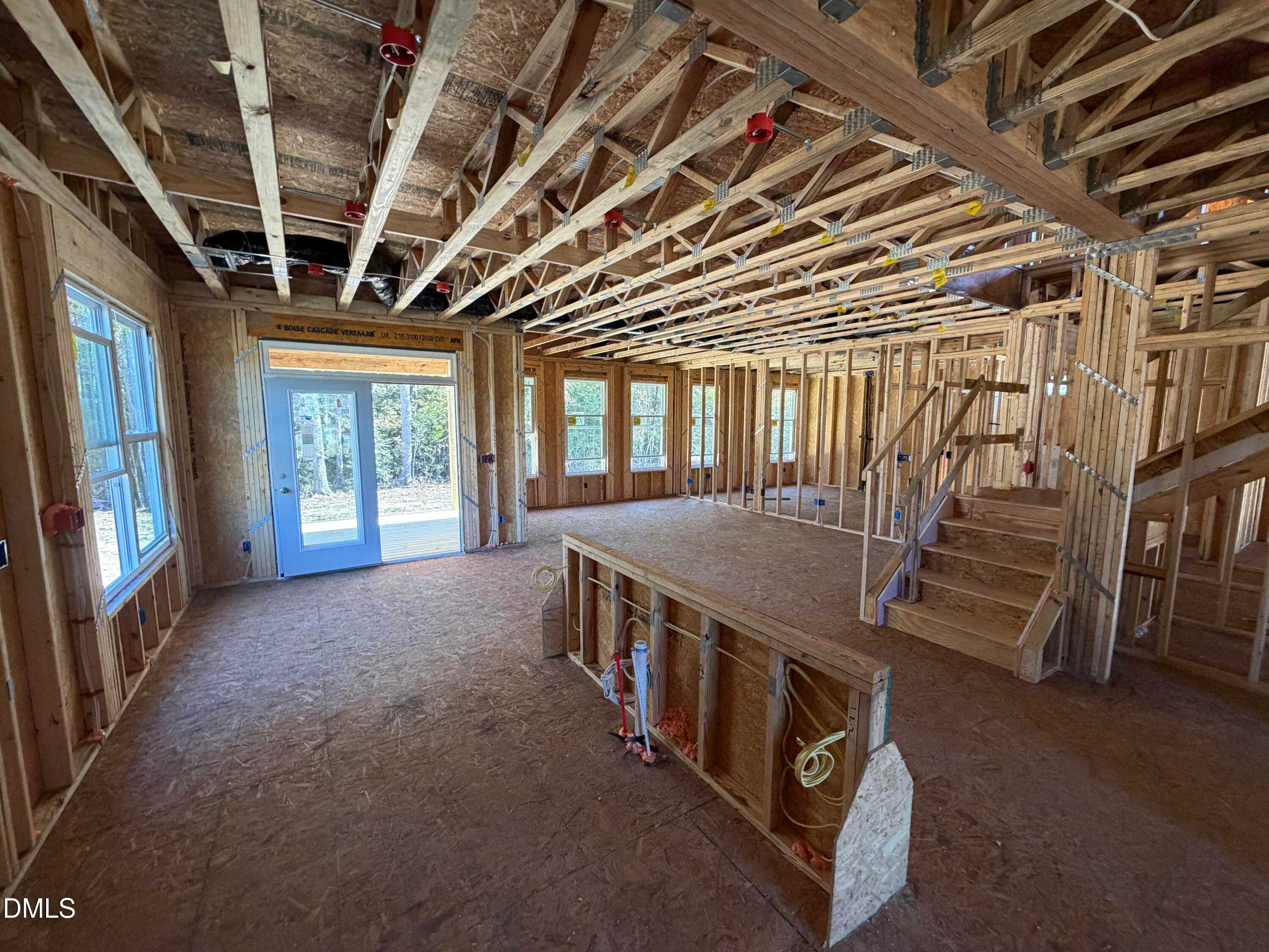Exposed wooden framing with staircase, large windows, and garage door in The Ash B 2-story home by Davidson Homes, Lillington, NC