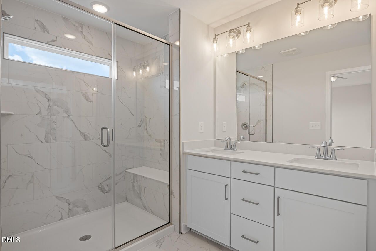 Modern bathroom with marble walk-in shower and double vanity in Davidson Homes' The Mitchell, Forestville Yard Townhomes, Knightdale NC