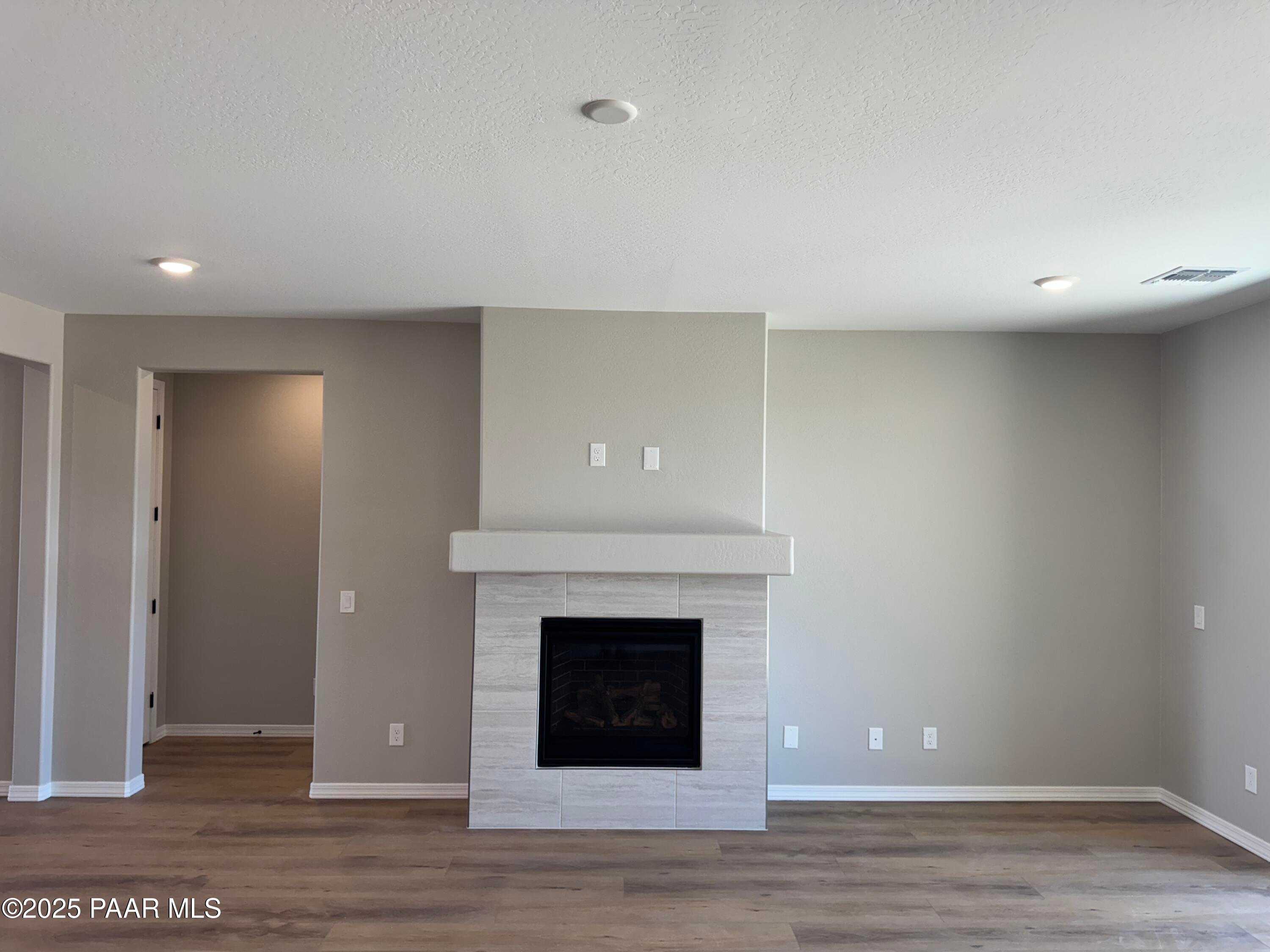 Elegant stone gas fireplace on accent wall in open living room, hardwood floors, The Sheridan II B by Davidson Homes, Prescott AZ