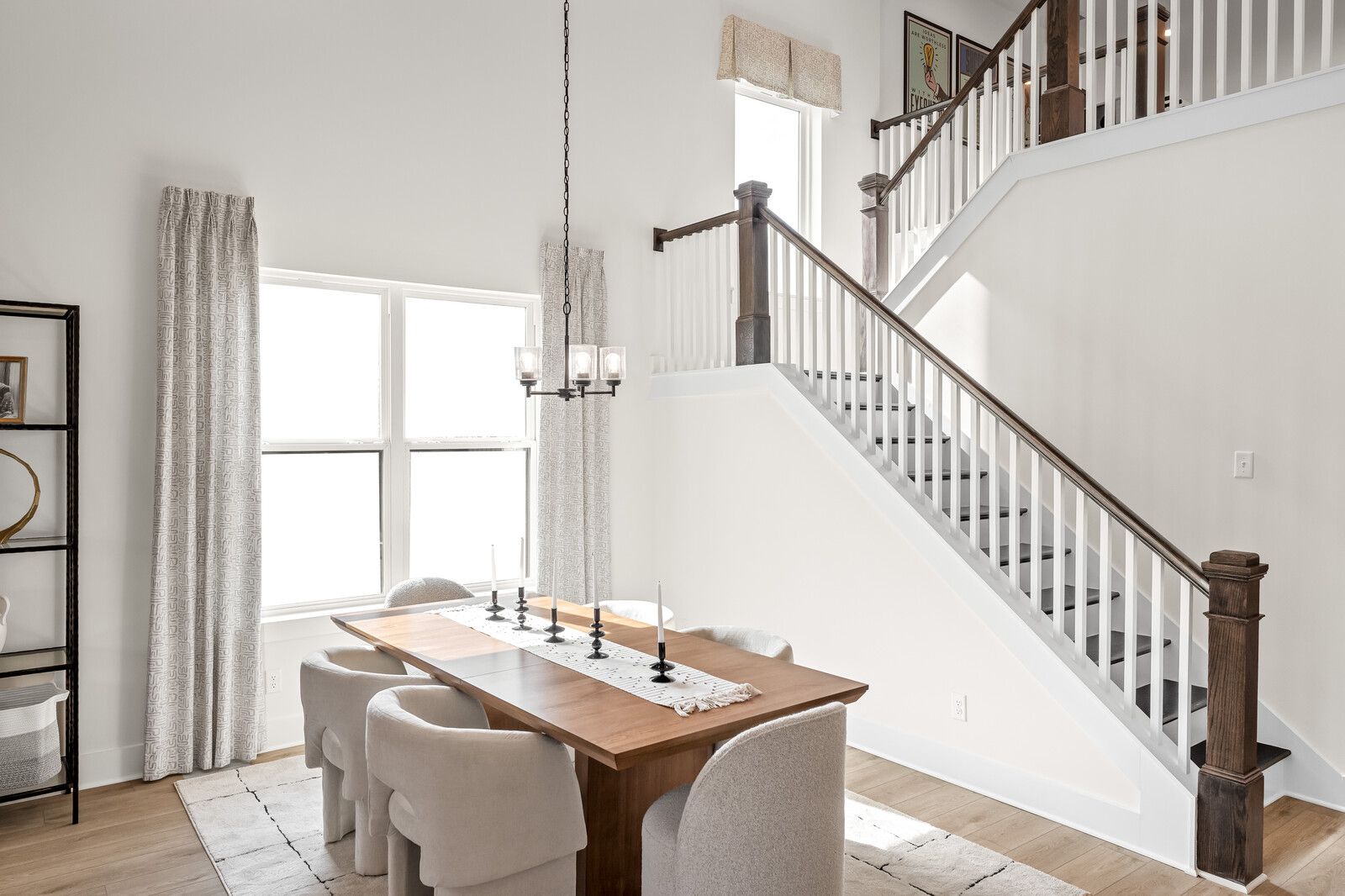 Open-concept living dining room at Benders Cove in Mt. Juliet TN featuring hardwood floors, neutral sofa, wood table and sheer curtains