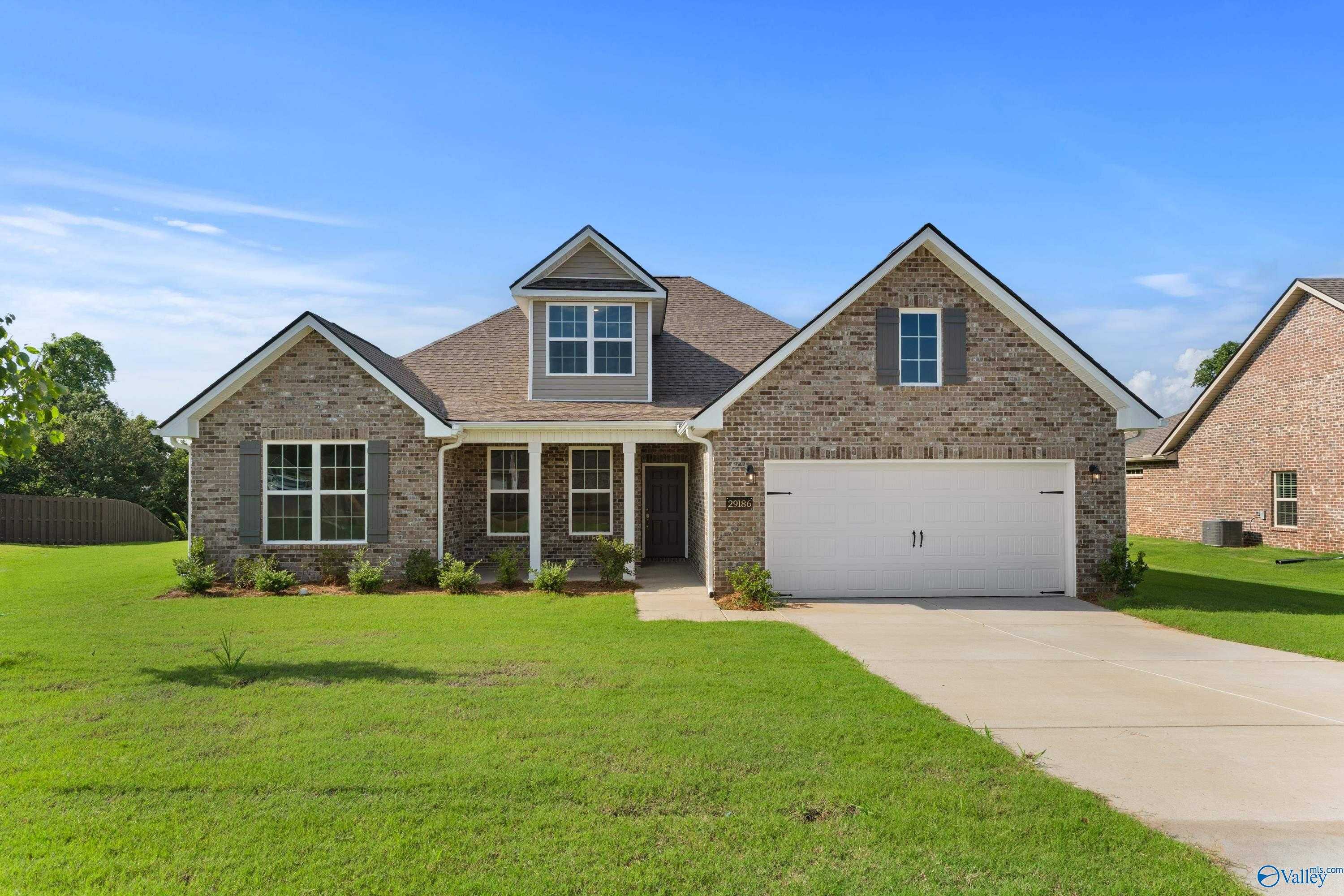 Brick single-story home with gabled roof, 2-car garage, driveway, and lush green lawn in Creekside, Harvest, Alabama - The Rockford by Davidson Homes