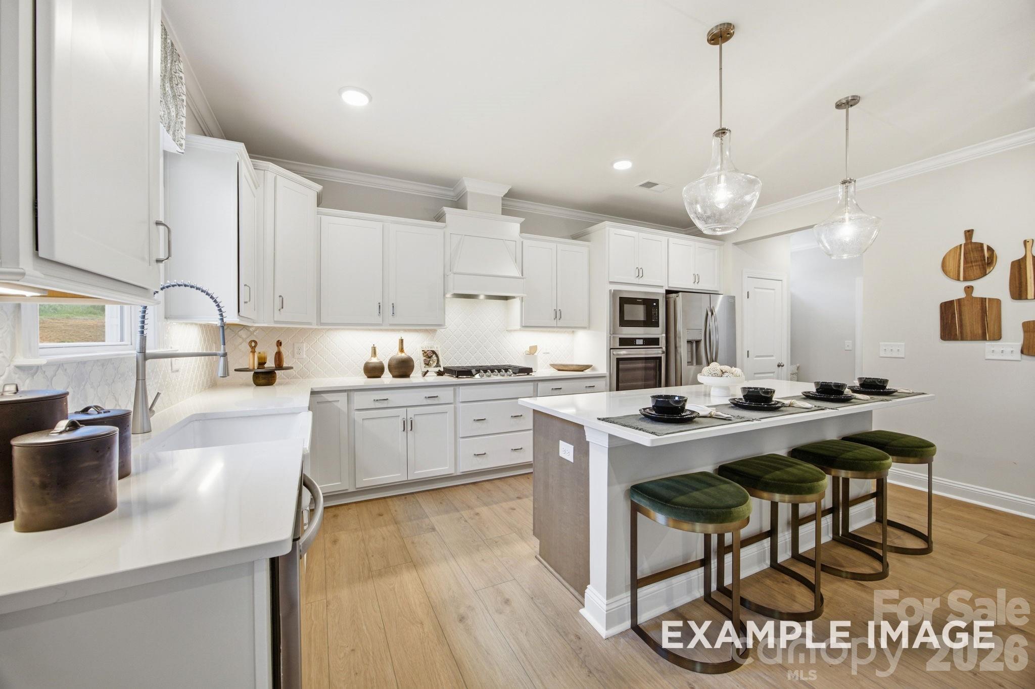 Modern white kitchen with island seating in The Hickory B II floor plan by Davidson Homes in Windgate, Mooresville, NC.
