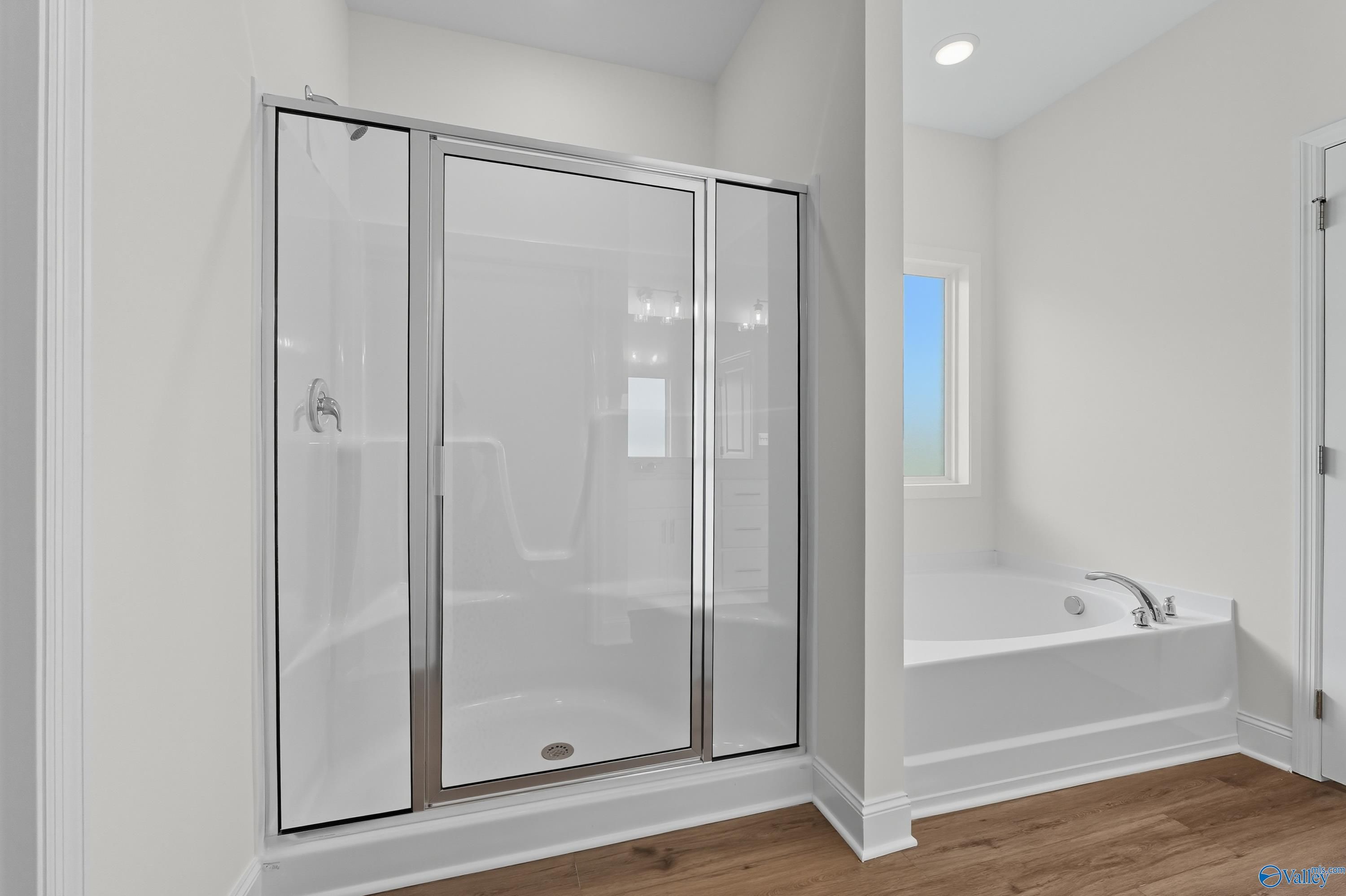 Elegant master bathroom with frameless glass shower and soaking tub in Davidson Homes The Everett, Meridianville Alabama