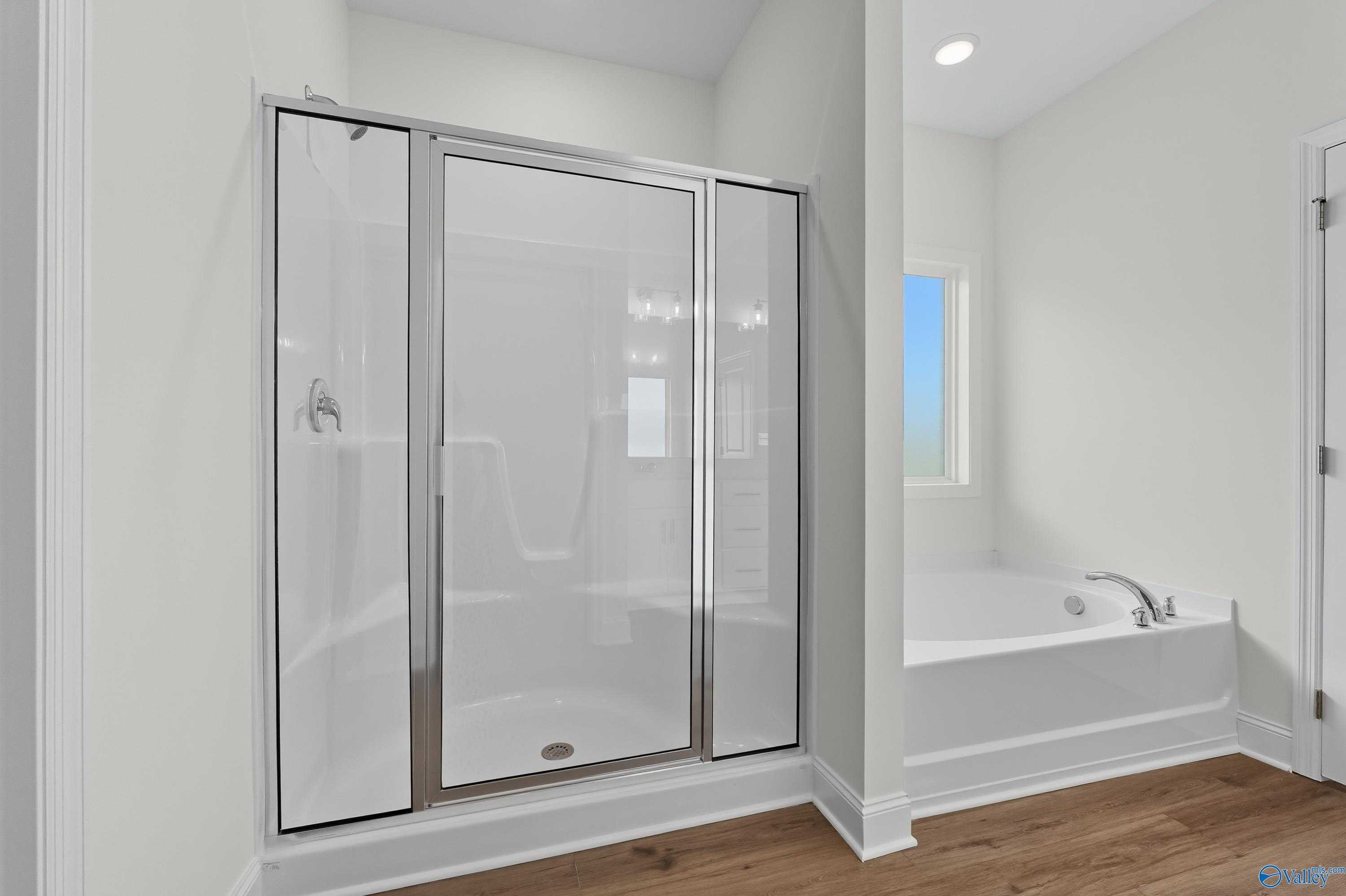 Luxurious master bathroom with frameless glass shower and soaking tub in Davidson Homes The Everett, Meridianville, Alabama