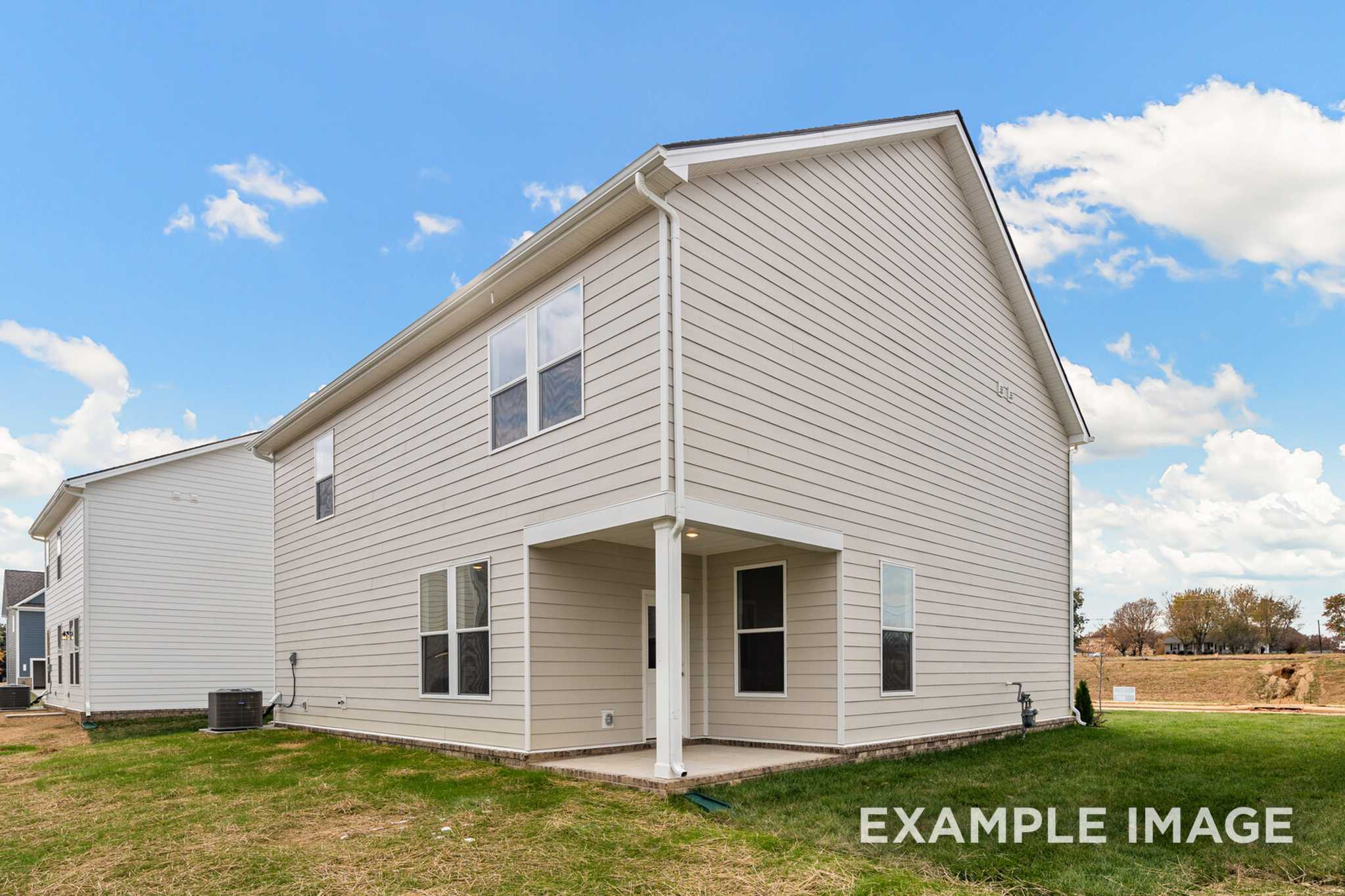 Side elevation of The Murray 2-story home featuring white siding, covered porch, garage, and lush green lawn