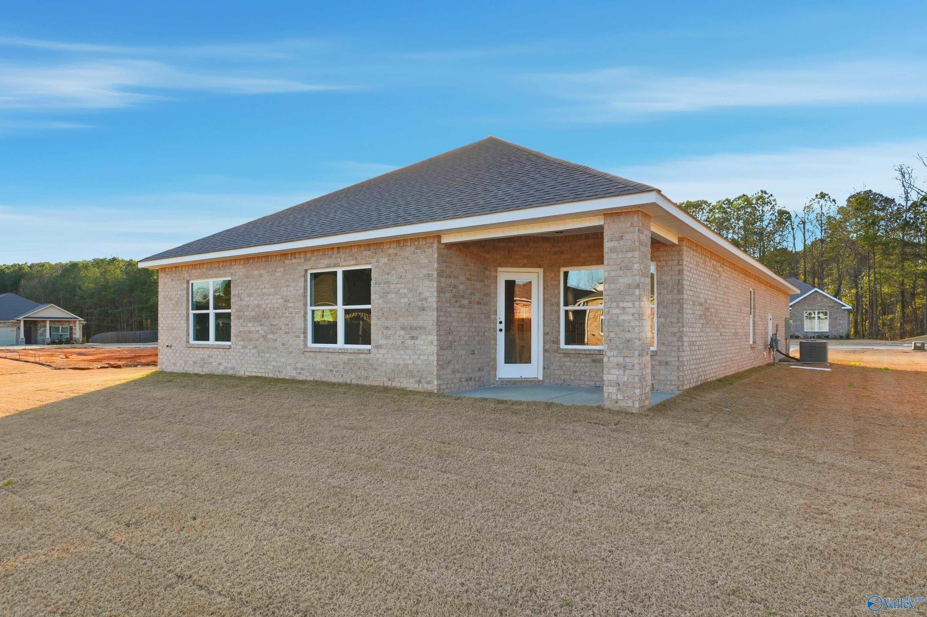 Single-story brick home with gabled roof, large windows, and covered entry on dirt lot in The Highlands, Arab, Alabama - Davidson Homes Daphne D