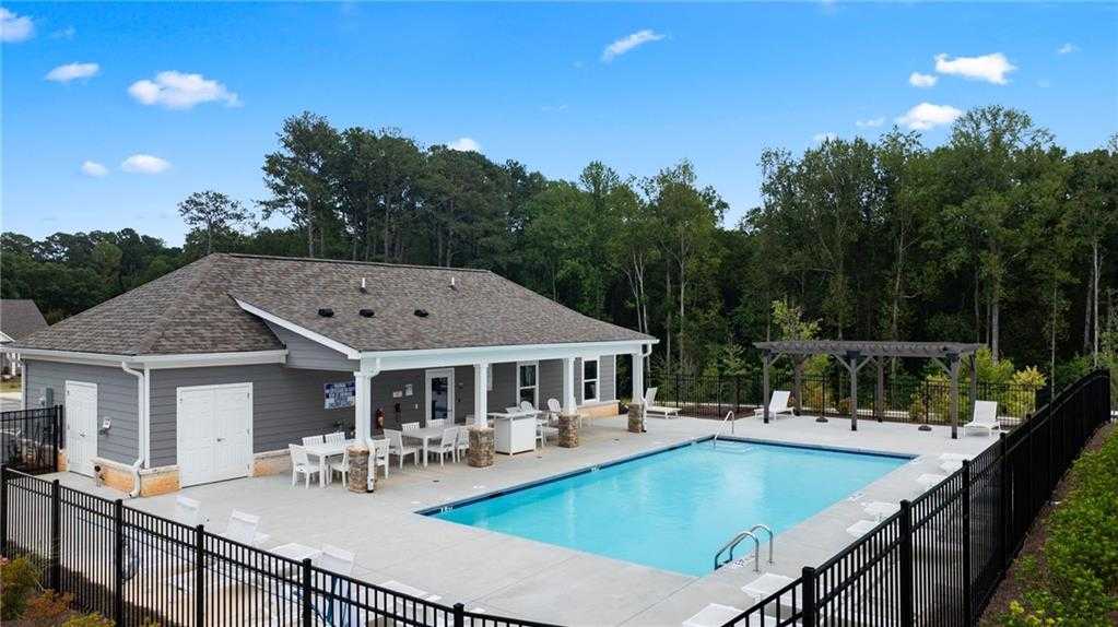 Community pool with pavilion, lounge seating, and pergola in lush wooded setting at Kelly Preserve, Loganville, Georgia