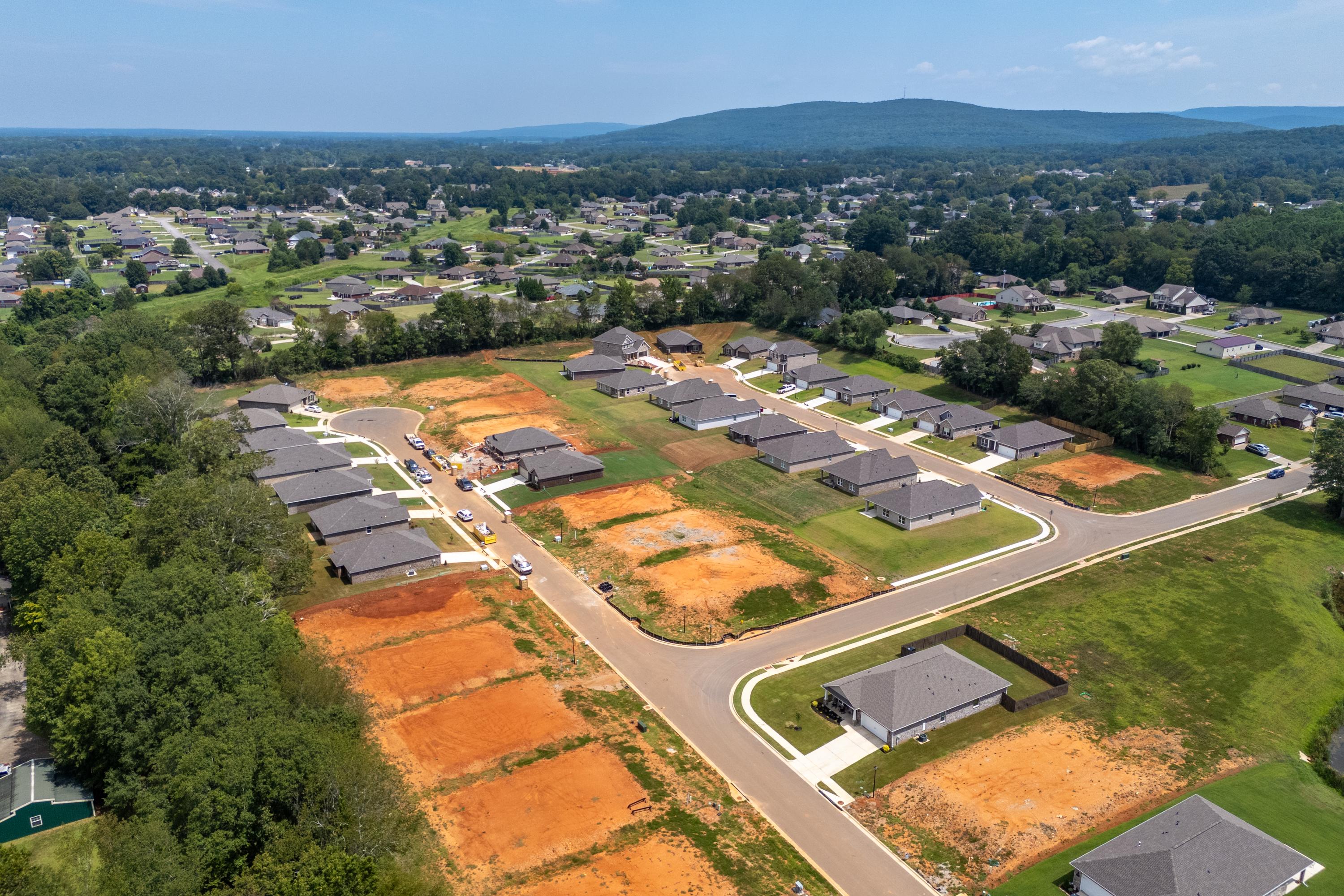 Aerial view of Flint Meadows in New Market Alabama featuring new homes construction sites and scenic wooded hills