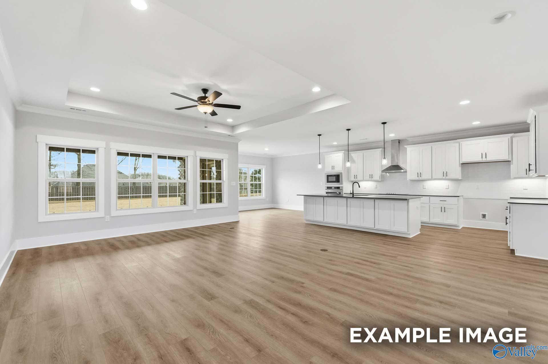 Open-concept living room and kitchen with white cabinetry in The Finleigh floor plan at Briercreek, Meridianville, Alabama.