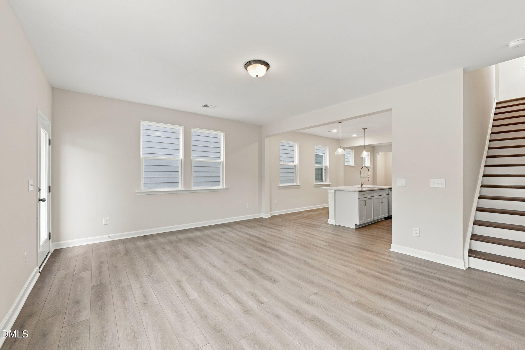 Open-concept living area with luxury vinyl plank flooring and kitchen island in Davidson Homes The Alexander B, Knightdale NC