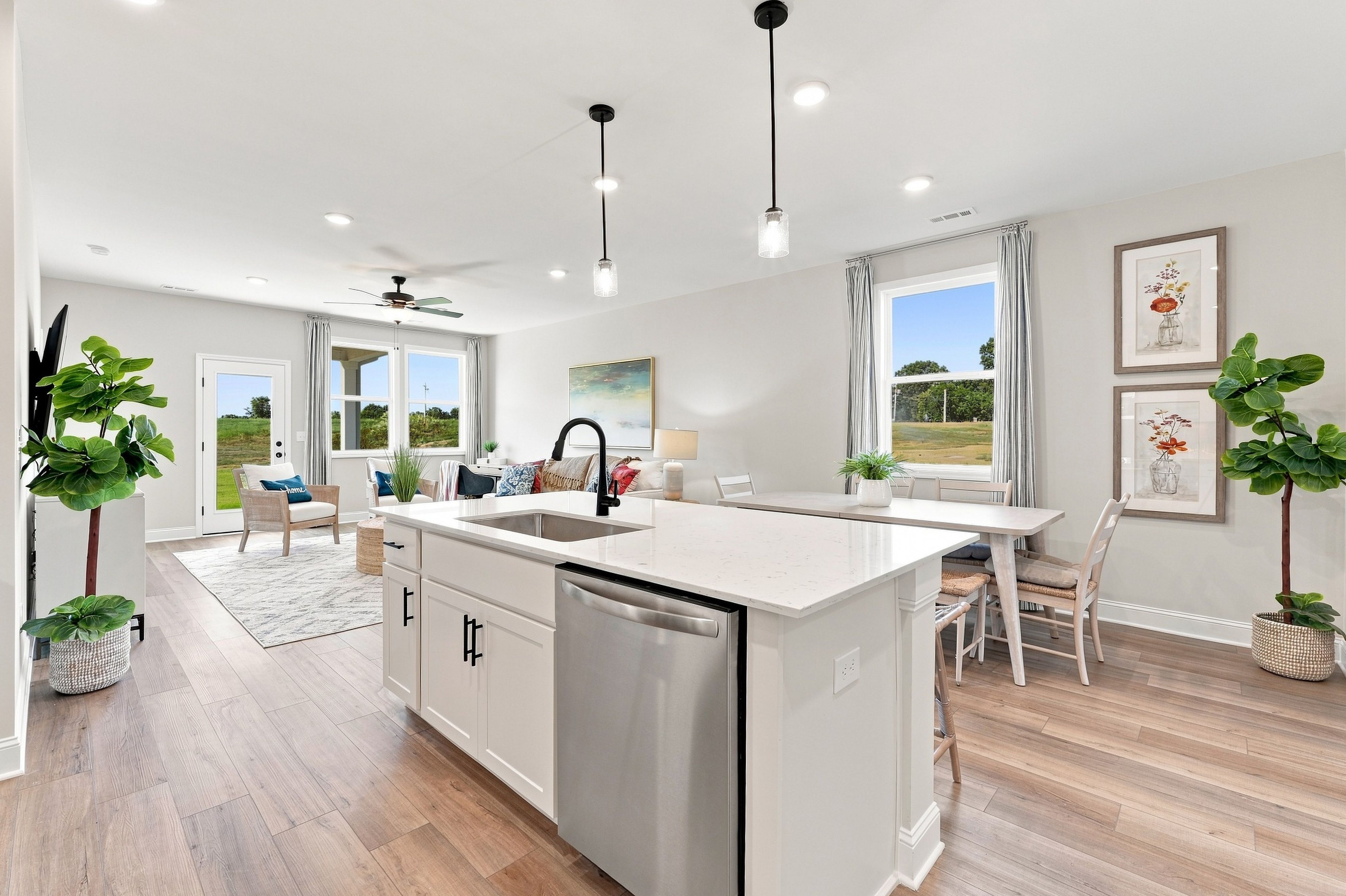 Open-concept kitchen with white island and stainless dishwasher at Bailey Park by Davidson Homes in Fayetteville, Tennessee