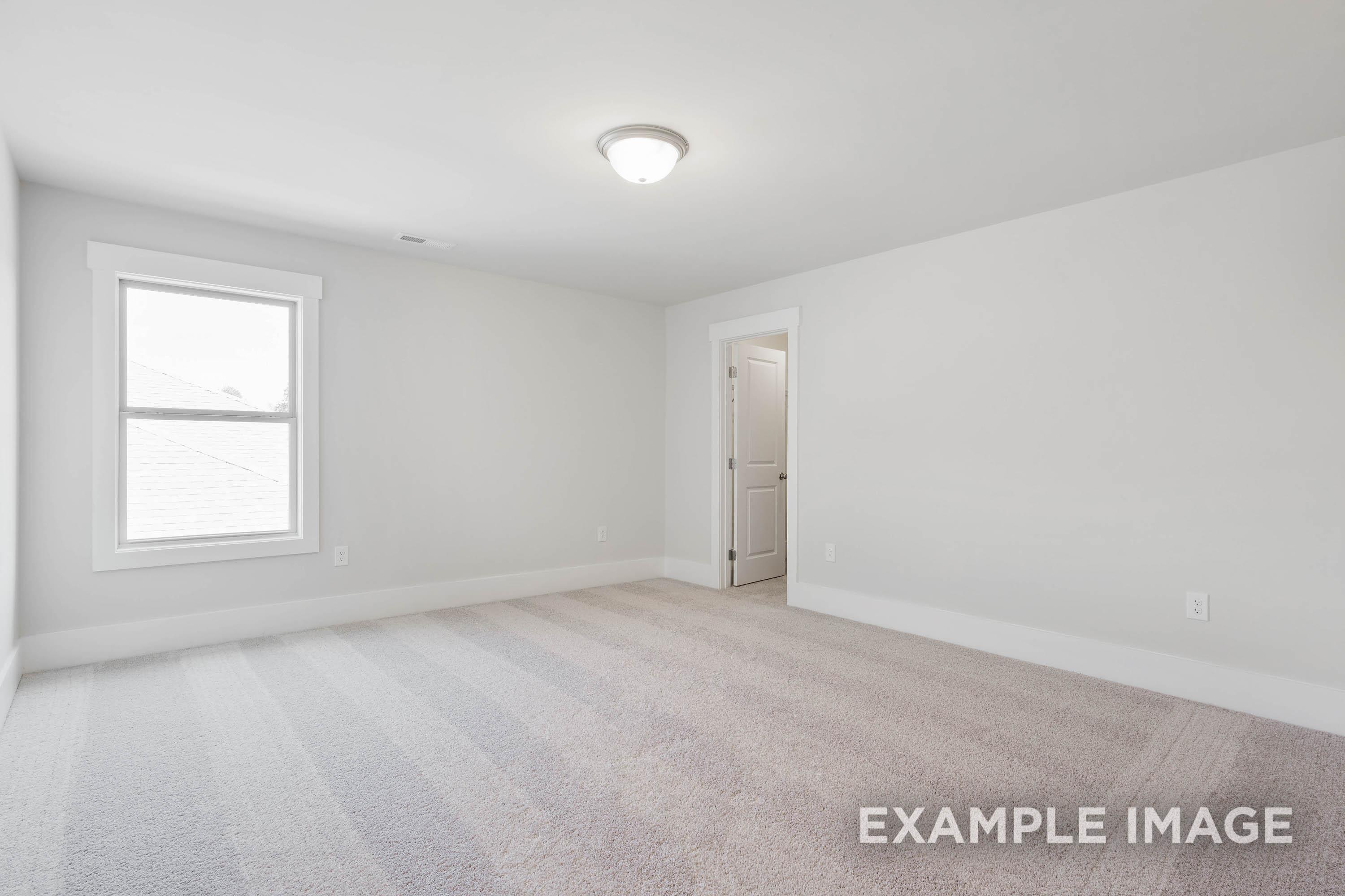 Spacious bedroom in The Richmond D featuring neutral carpet, clean white walls, and bright natural light.