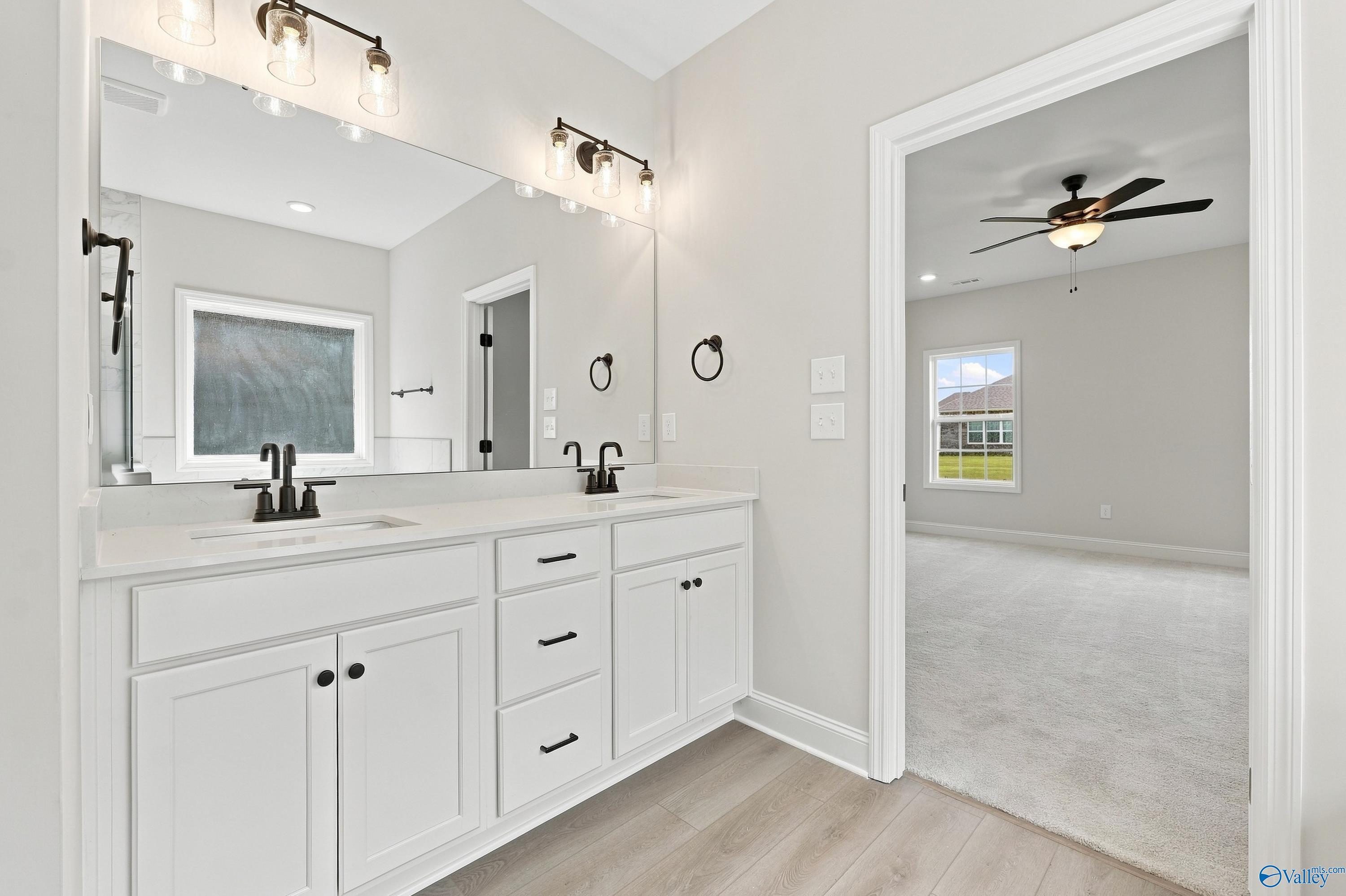 Double vanity bathroom with white cabinets and matte black fixtures in The Rockford B floor plan, Kendall Downs, Toney, AL.