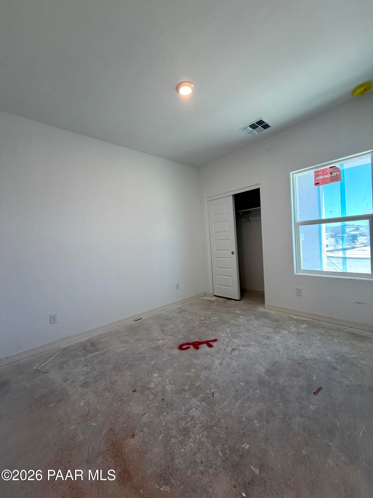 Unfinished bedroom with walk-in closet and large window in new construction Davidson Homes Marietta C plan, Prescott AZ