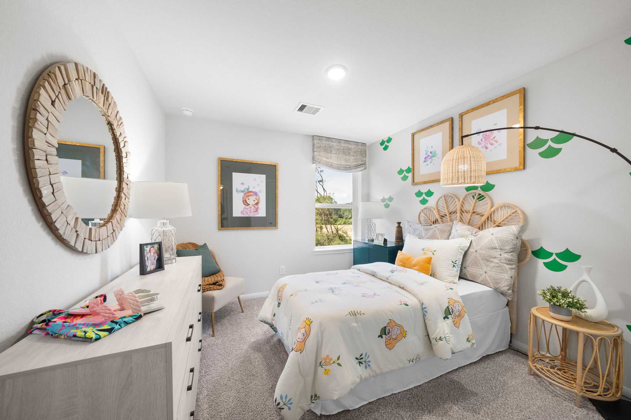 Cozy girl's bedroom at Caney Creek Place in Conroe TX with rattan headboard, orange quilt, green leaf accents, and round mirror