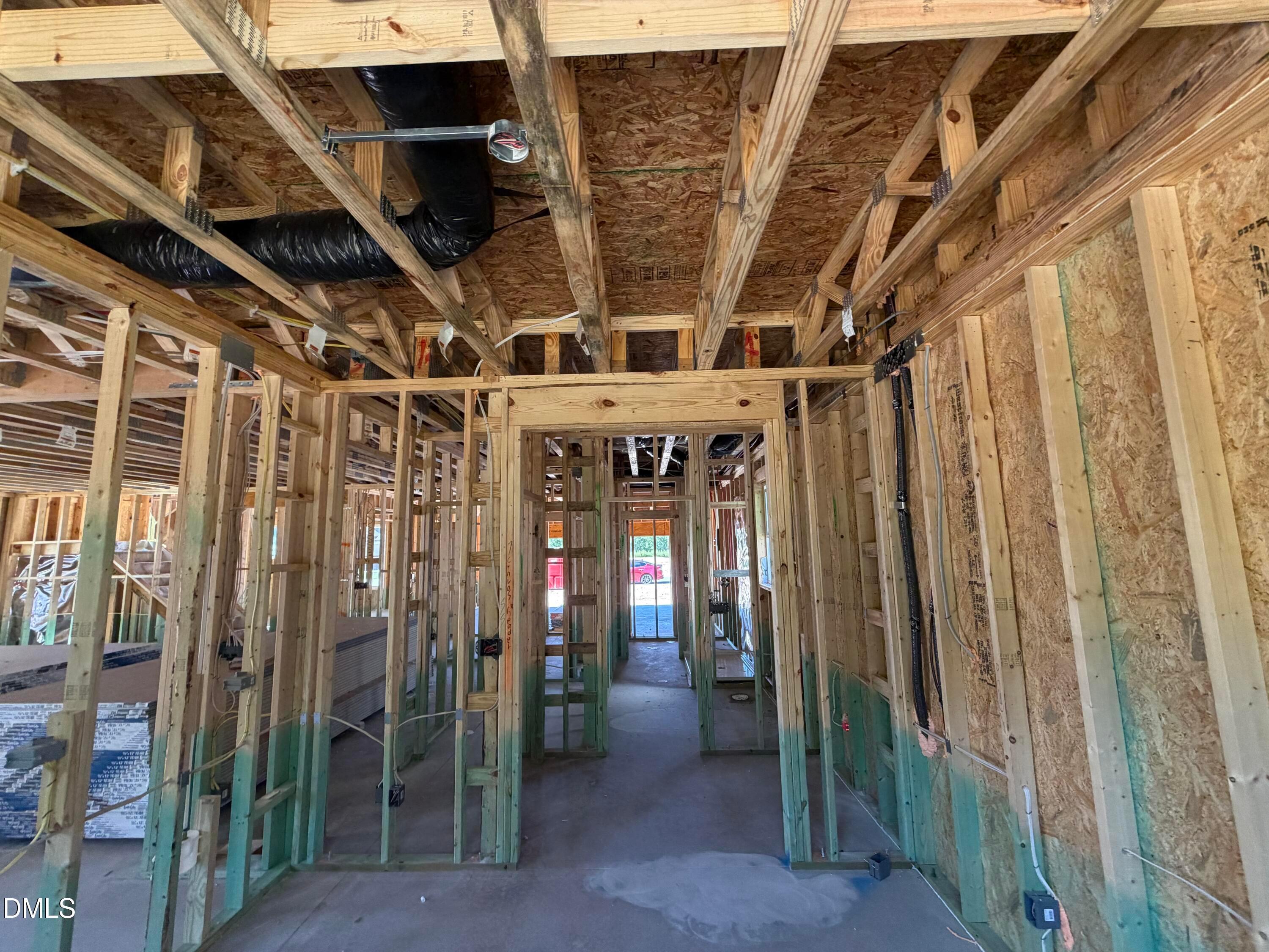 Wood-framed interior under construction showing exposed studs and ductwork in Davidson Homes' Aspen C floor plan at Wendell Ridge, NC