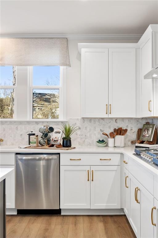 Modern white kitchen with quartz counters, stainless dishwasher, gold accents, and scenic window view in Davidson Homes The Aspen A, Buford, GA