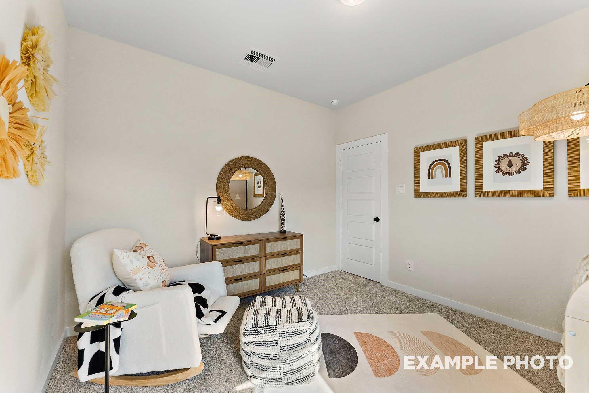 Boho-style nursery with rocking chair and rattan decor in The Everett E floor plan at Sundance Cove, Crosby, Texas.