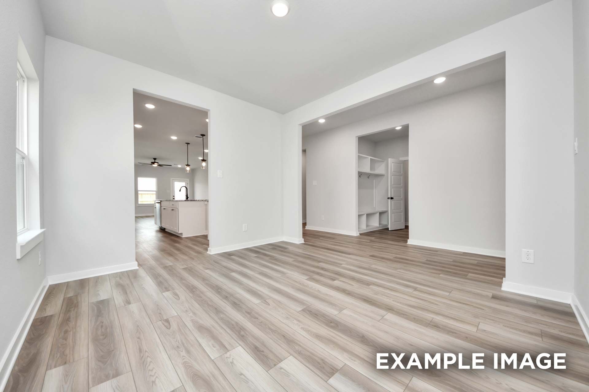 Open-concept living area in The Sorrento with wood-look flooring, recessed lighting, and view into kitchen and mudroom.