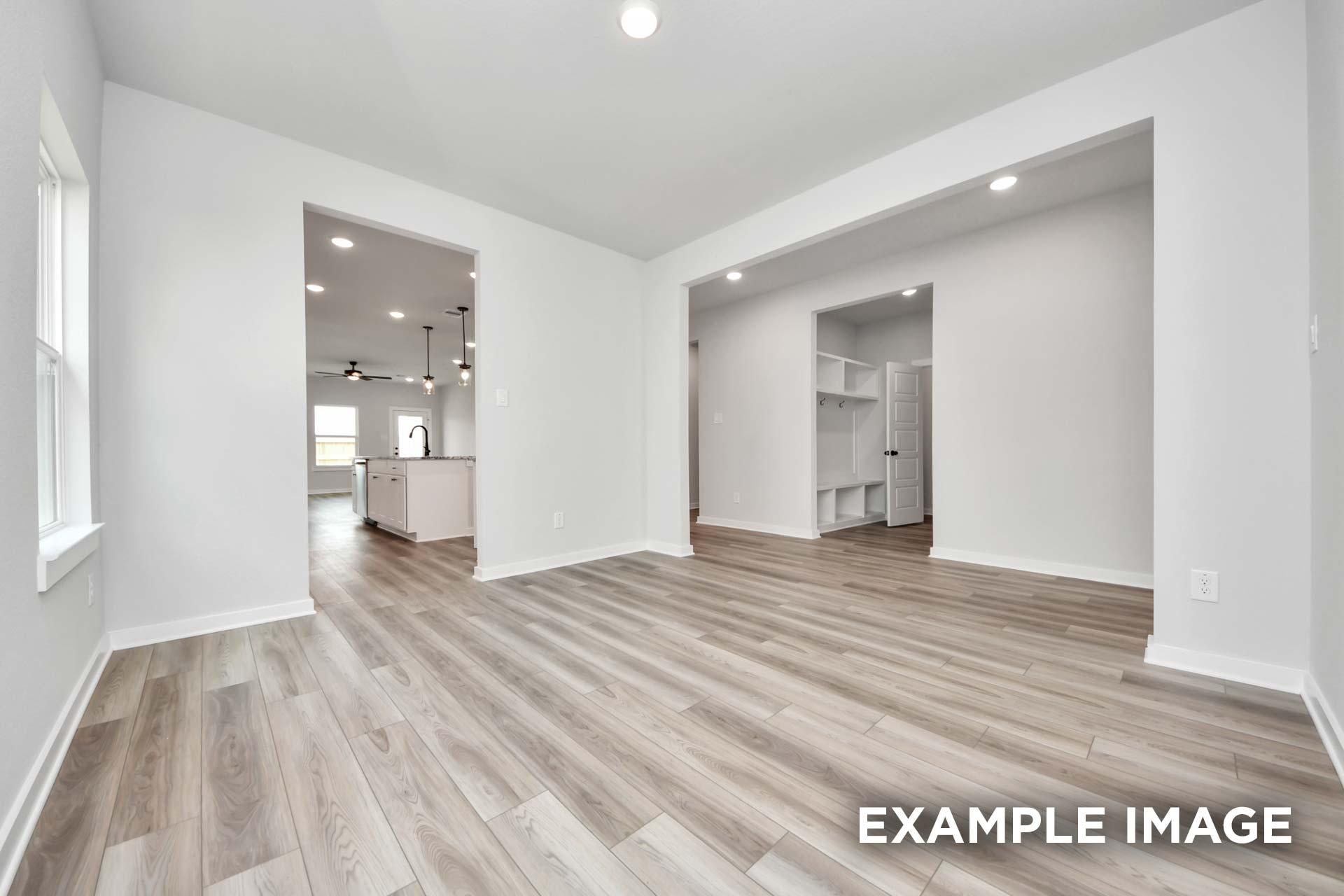 Open-concept living area in The Sorrento with wood-look flooring, recessed lighting, and view into kitchen and mudroom.