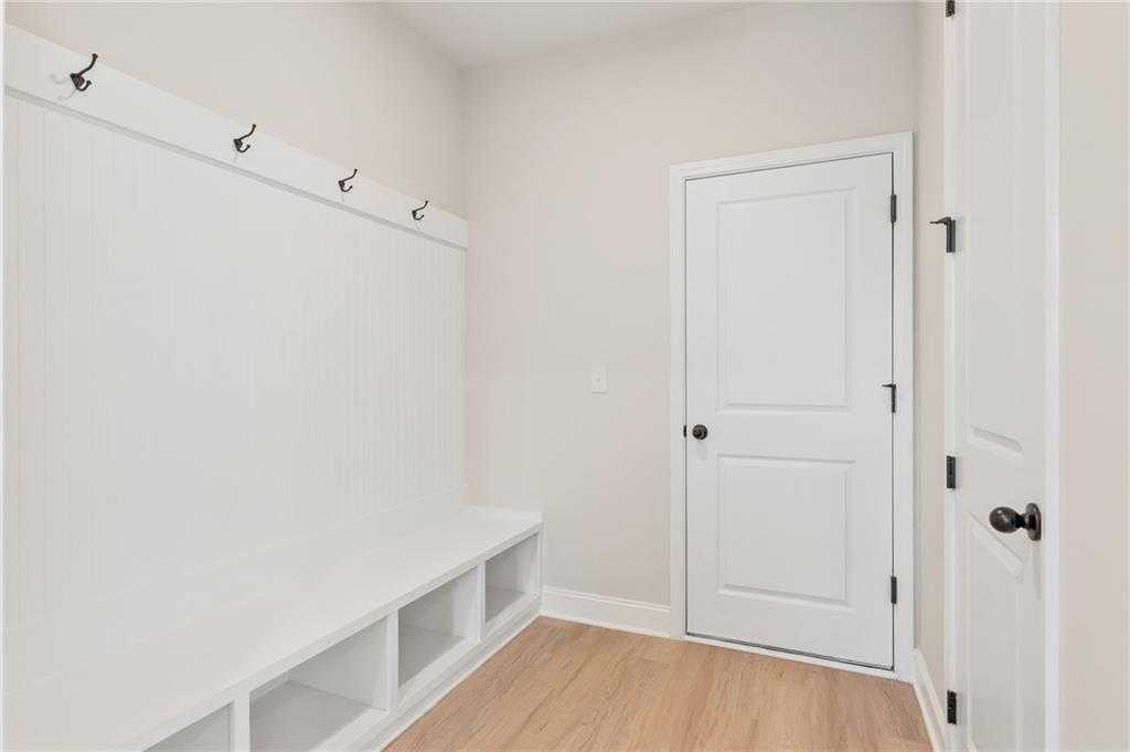 Functional mudroom with wall hooks, built-in bench and cubbies in Davidson Homes The Hickory B, Buford, Georgia