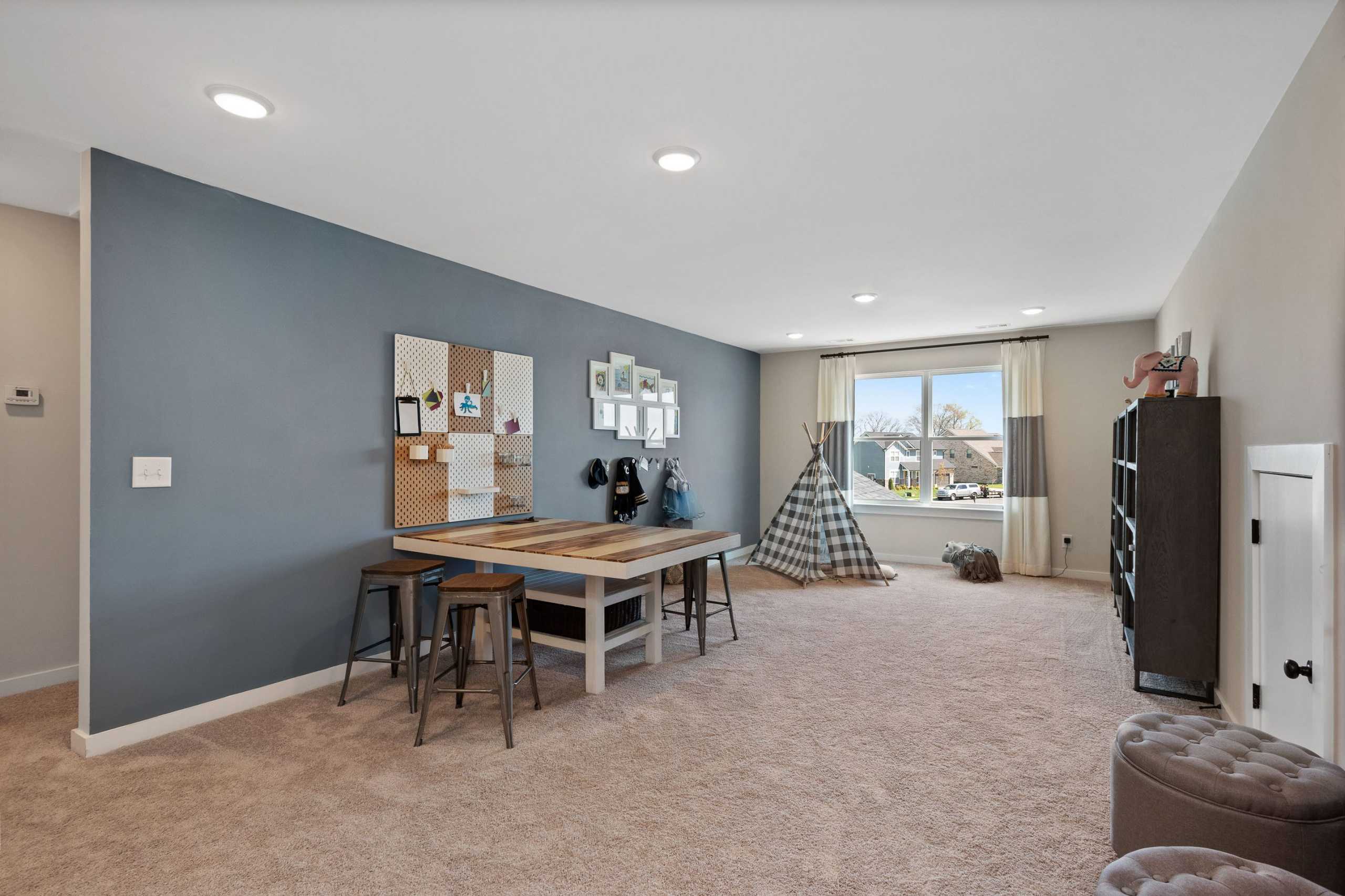 Children's playroom at Rivers Edge in Murfreesboro TN with teepee tent, wooden table, corkboard and bookshelf