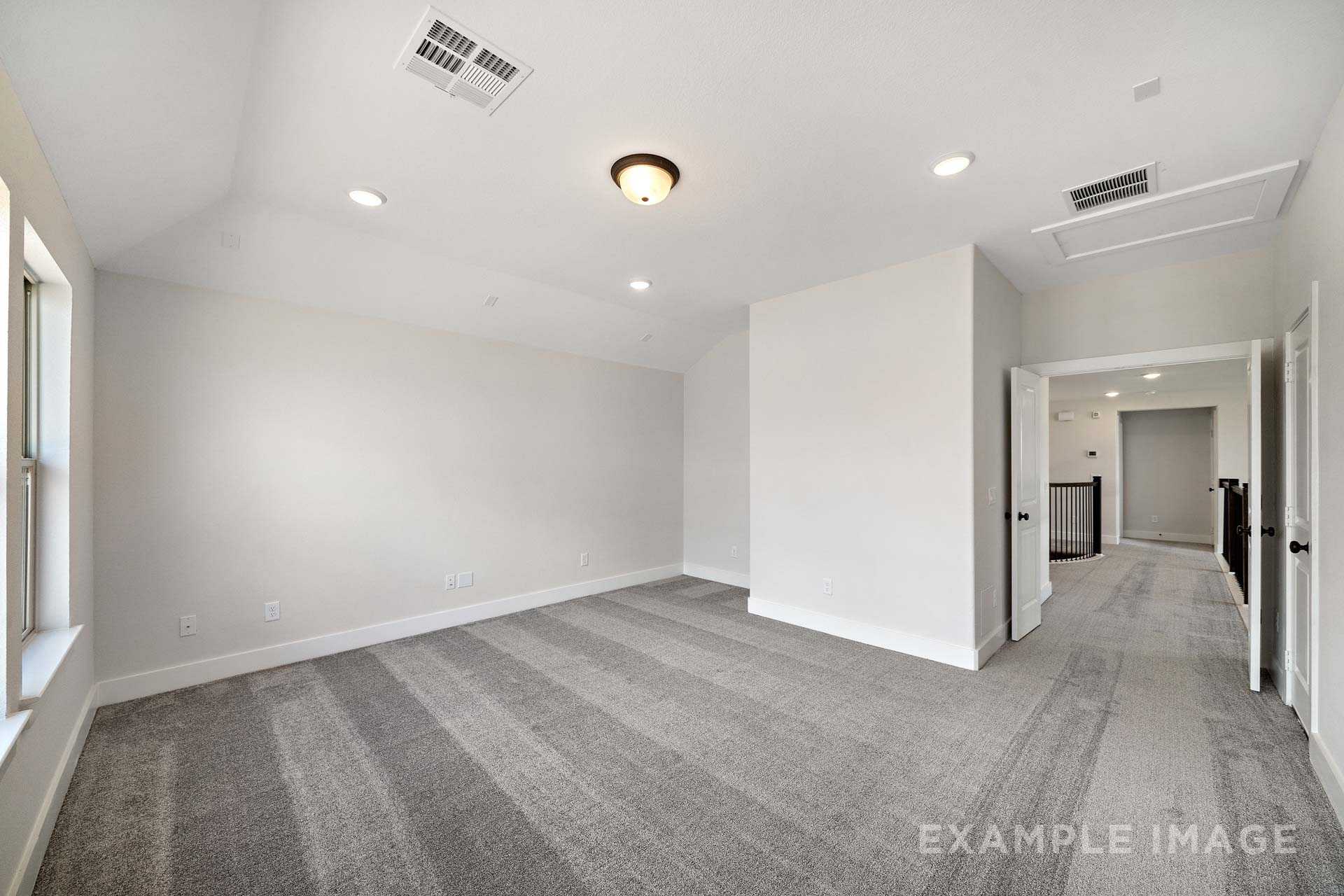 Spacious upstairs bonus room in The Victoria A with gray carpet, vaulted ceiling, recessed lights, and hallway access via open doors