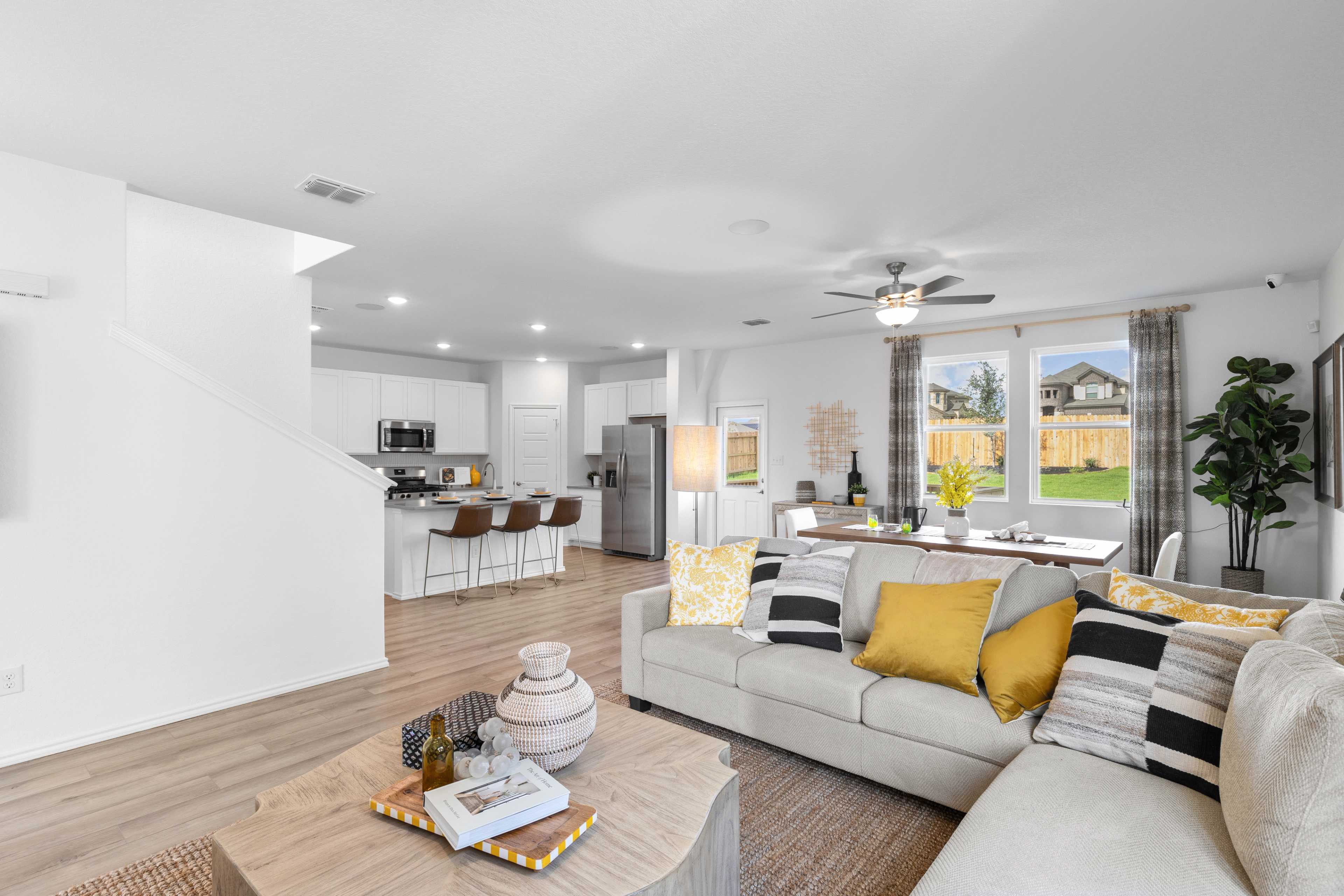 Spacious open-concept living room and kitchen at Horizon Pointe in Converse Texas with hardwood floors, white cabinets, and beige sofa