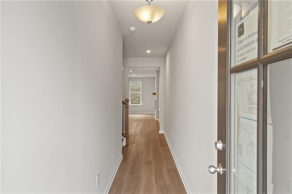 Bright entry hallway with hardwood floors, white walls, and modern lighting in Davidson Homes The Marion B, Kennesaw, GA