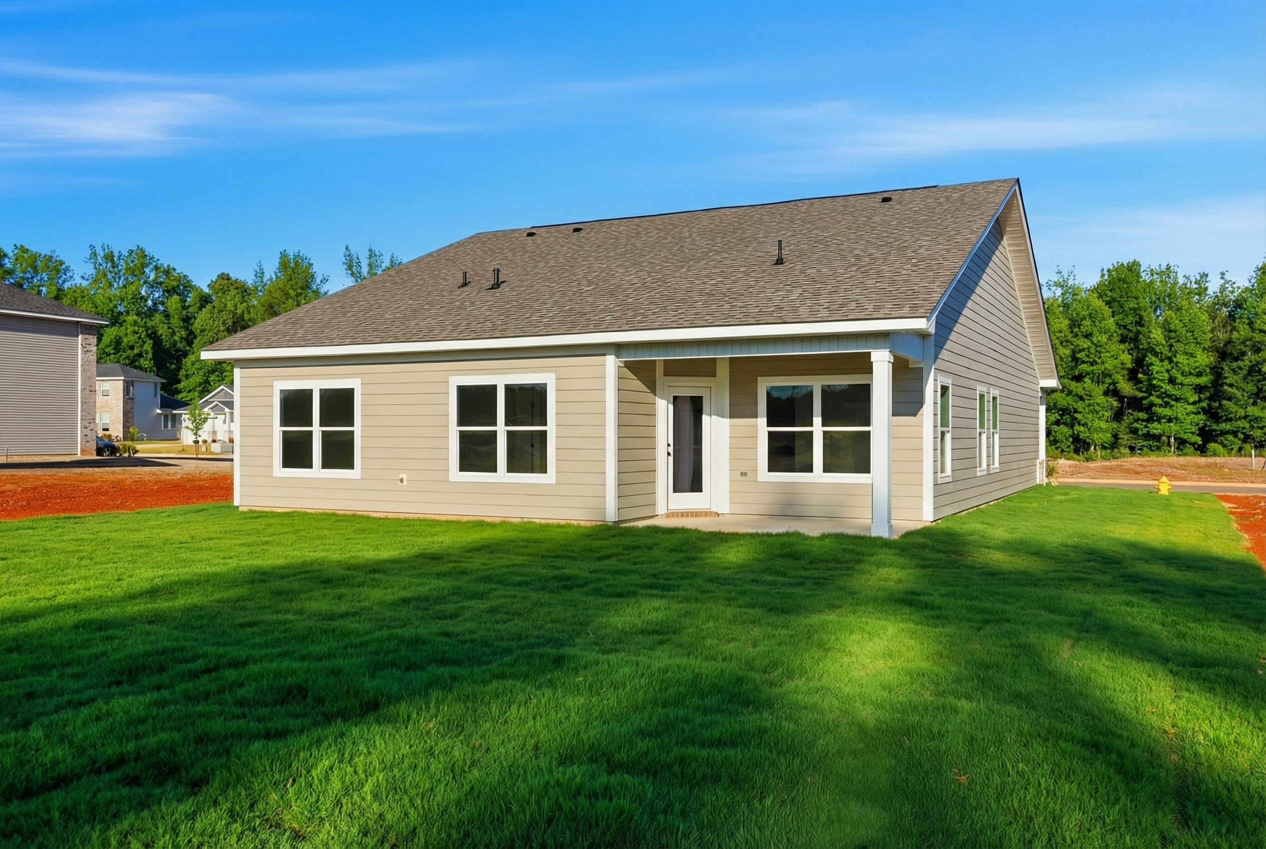 Charming single-story home exterior at Bailey Park in Fayetteville TN with beige siding, gabled roof, and lush green lawn