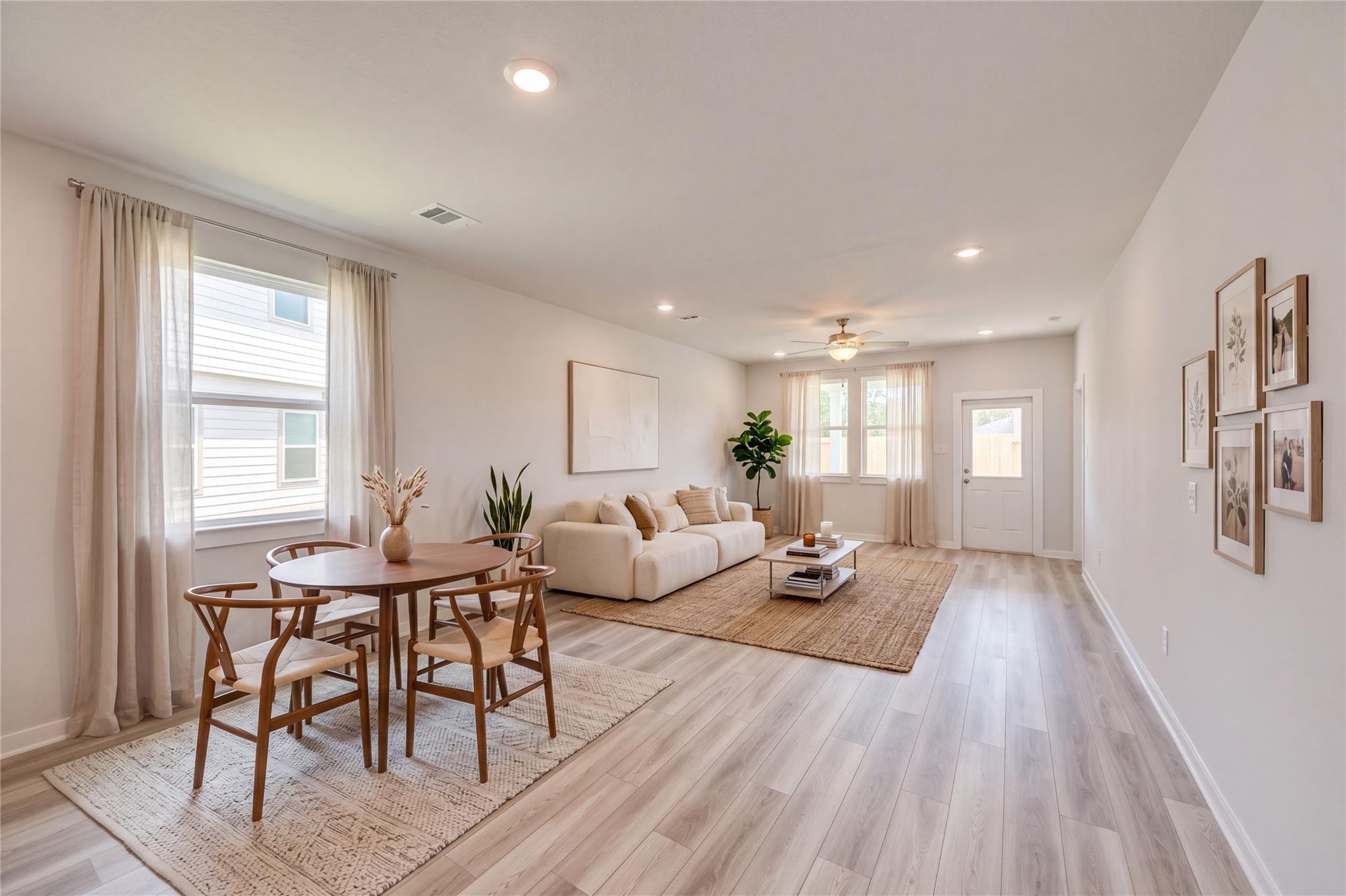 Bright open-concept living and dining area with wood-look flooring in Davidson Homes' The Sabine F, Liberty Estates, Cleveland, Texas.